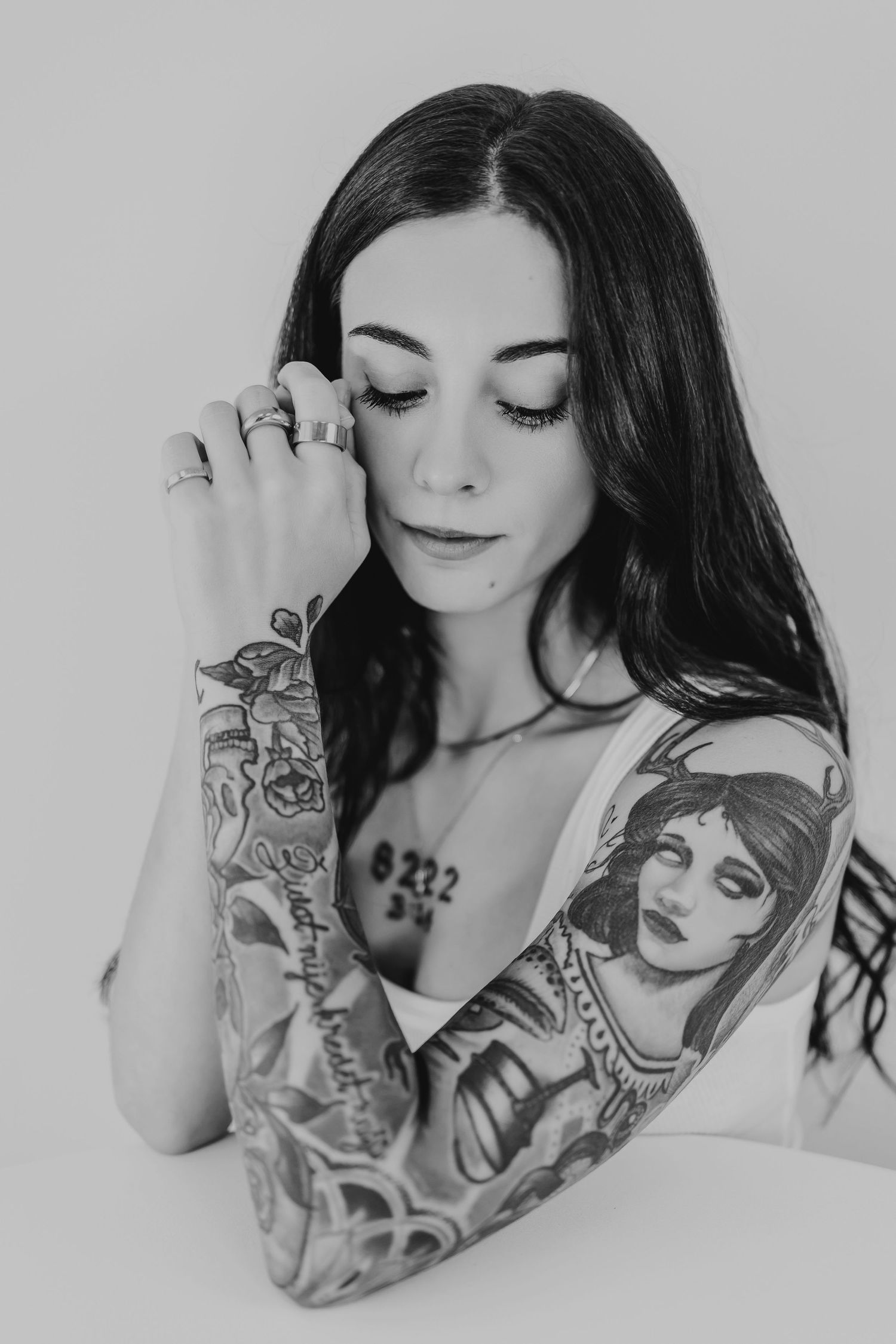 Black and white artistic portrait series featuring dark hair and sleeve tattoos in a minimalist style.