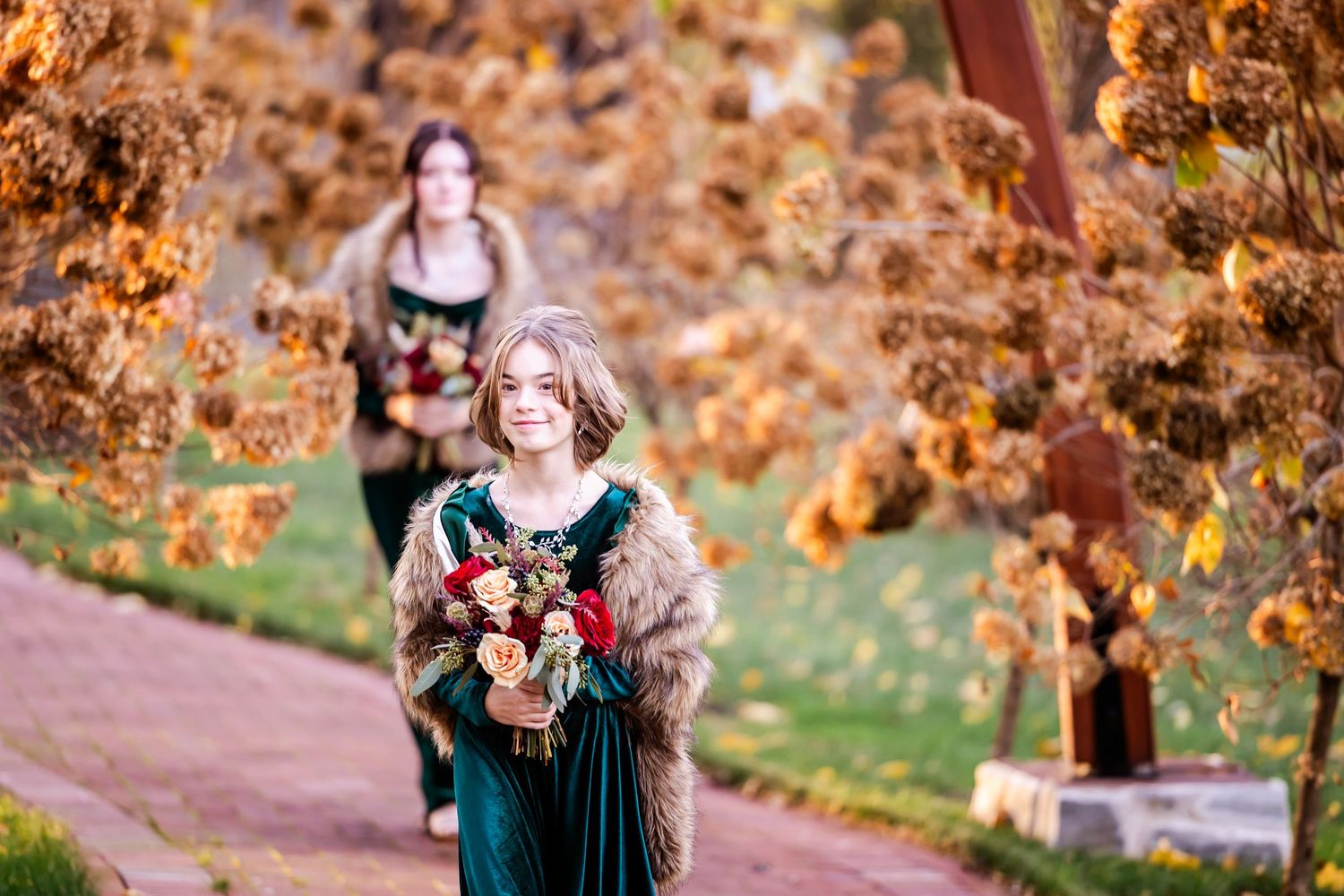 An autumn wedding scene with warm golden colors and fall foliage in the background.