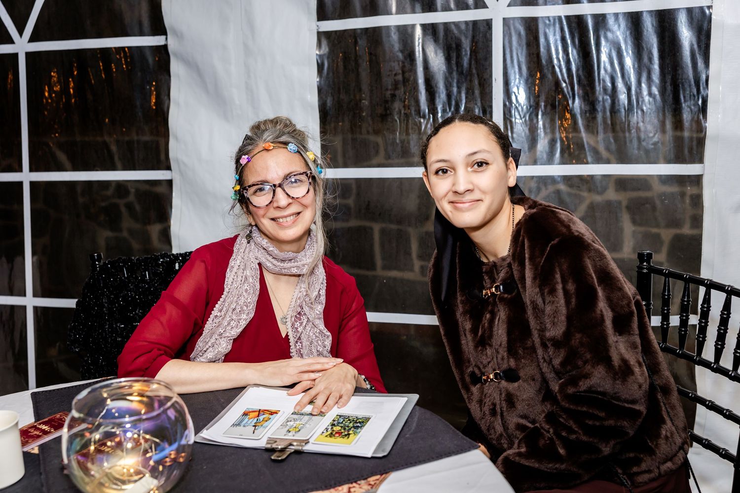 Two guests sit at a wedding reception table reviewing documents.