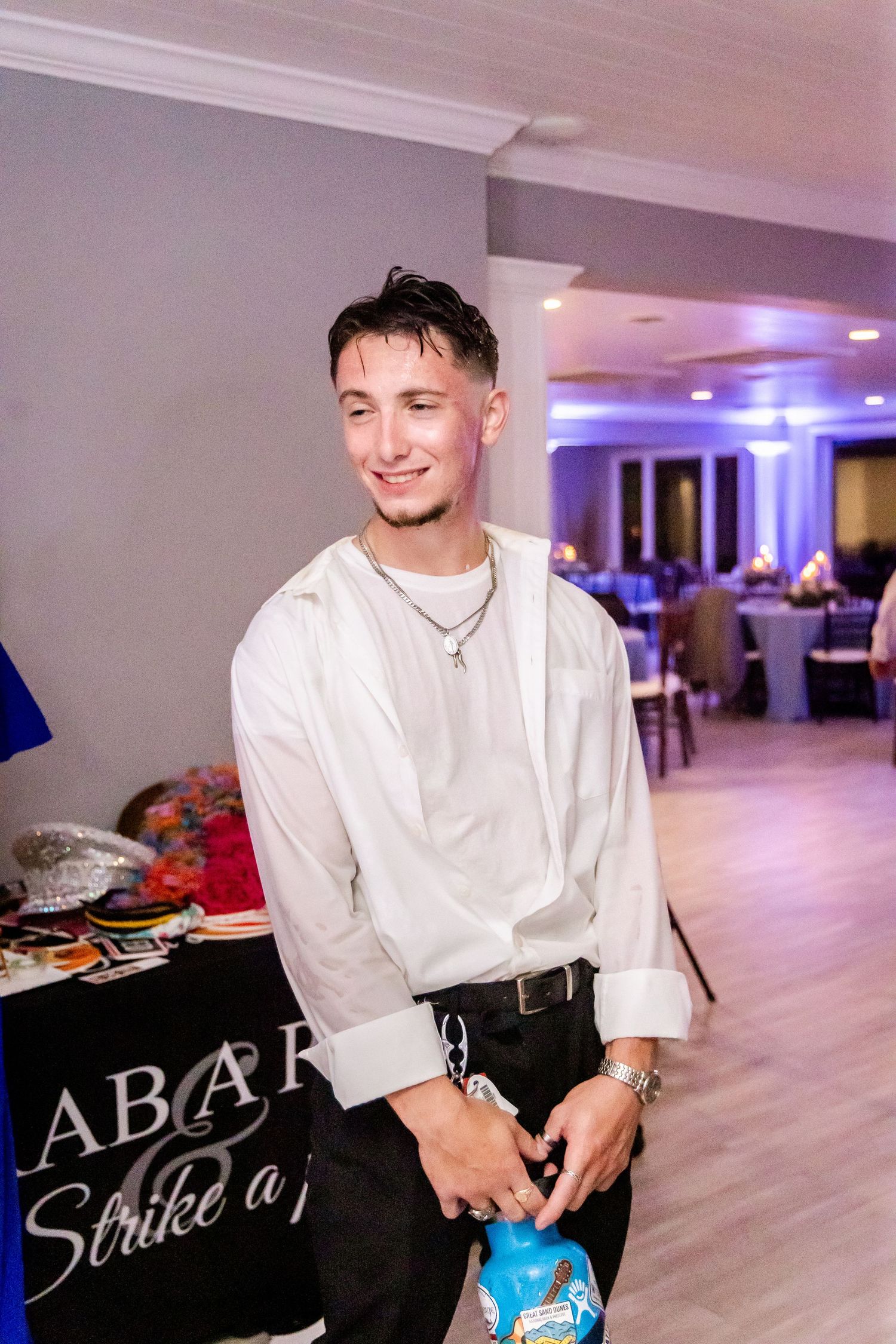 Staff member in white shirt setting up bowling equipment at wedding reception.