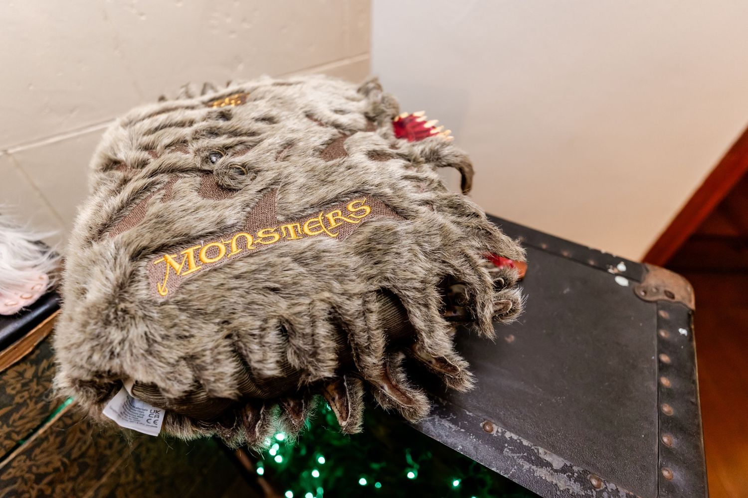 Gray fur-textured book with Monster's logo displayed on dark surface.