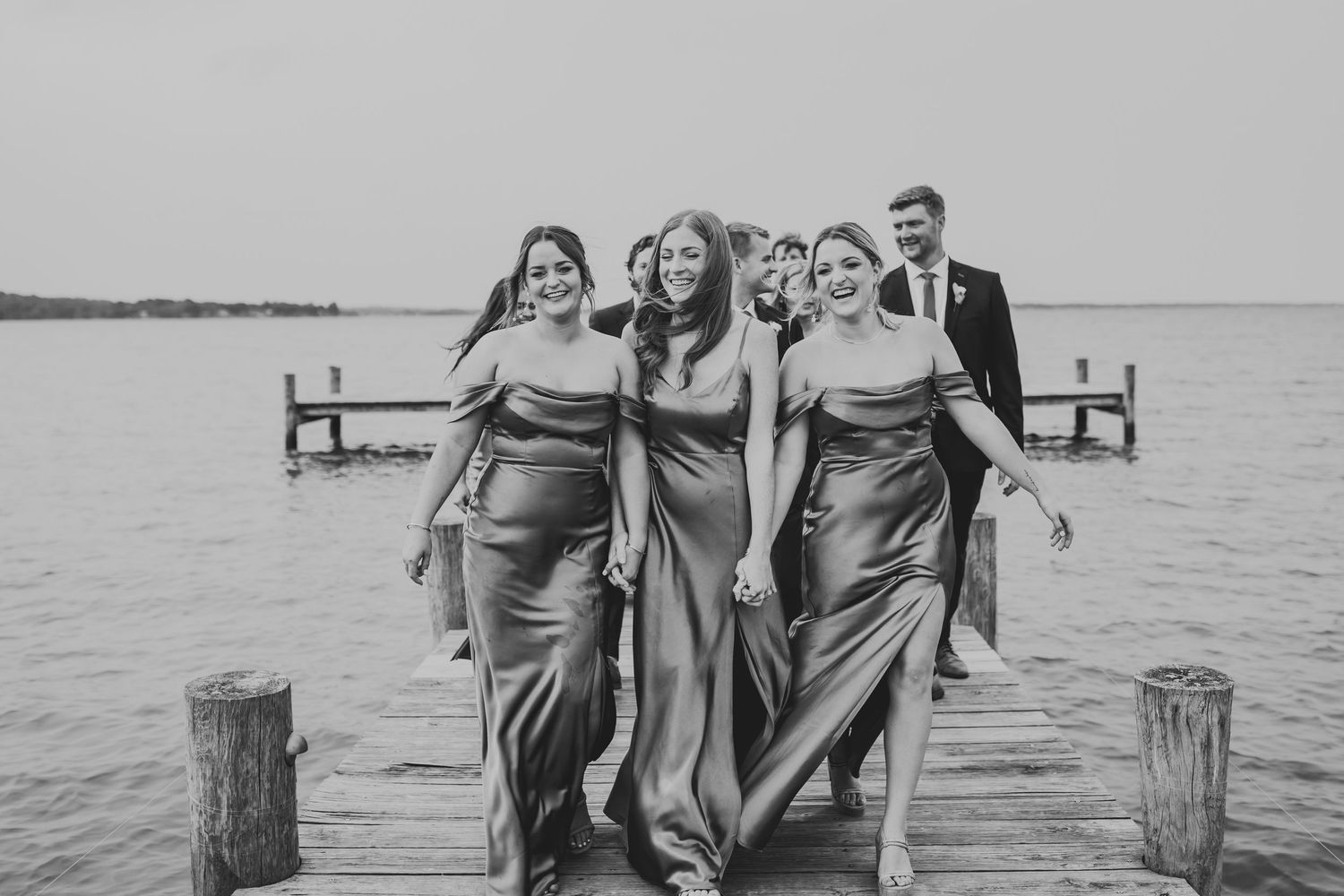 People in matching dresses posing near a lake in a collection of outdoor scenes with rustic views.