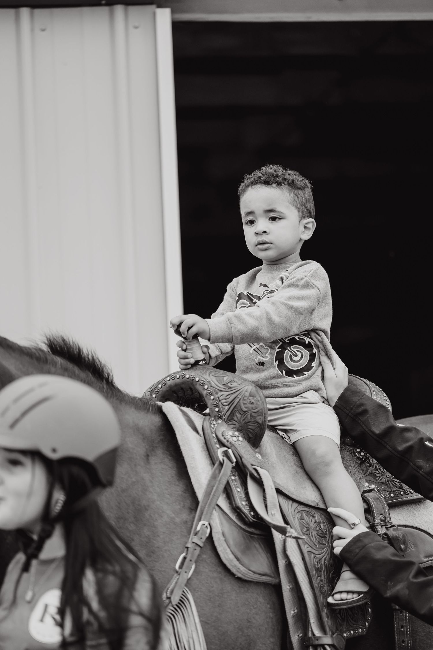Young rider sits atop a horse wearing western riding gear.