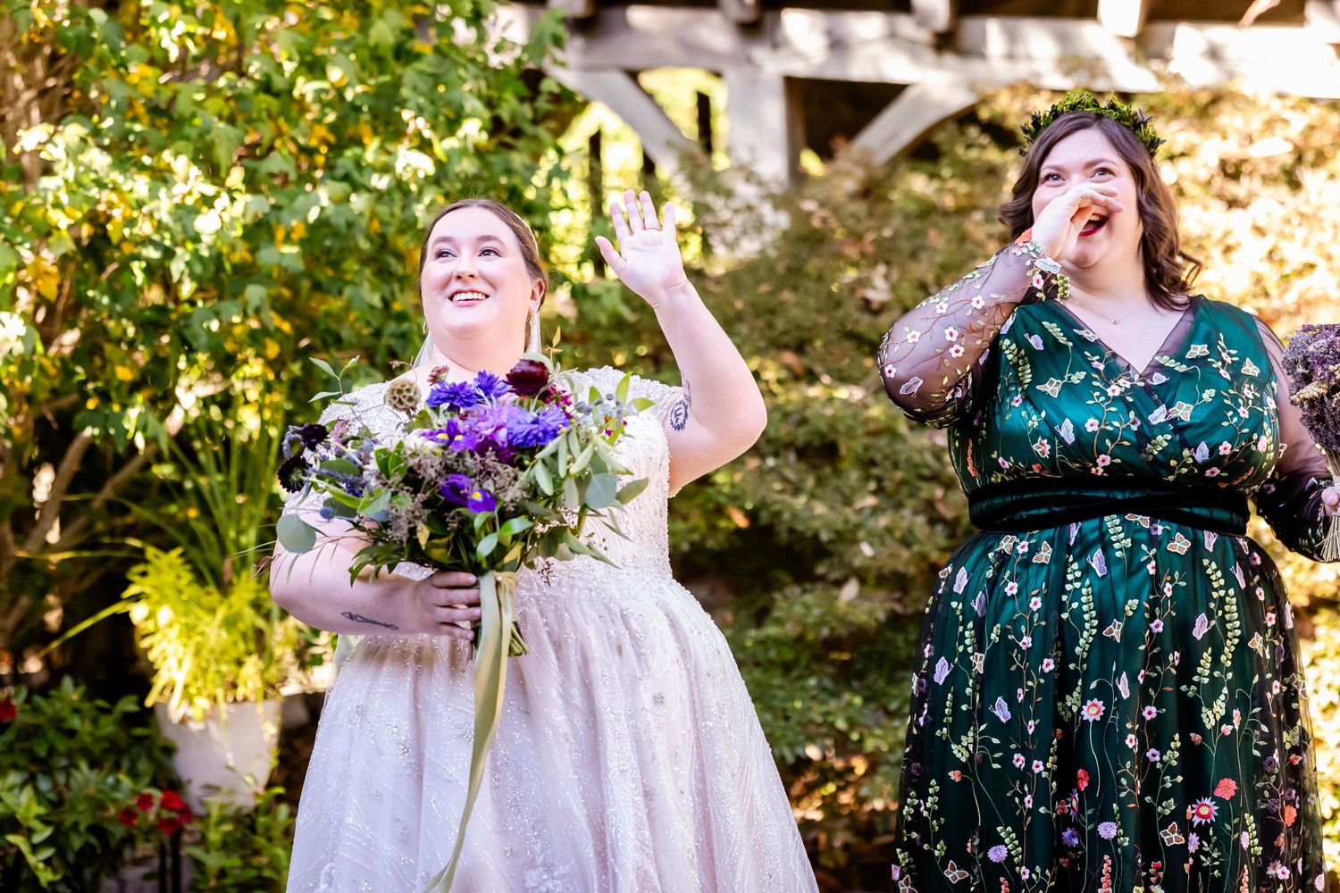 Two guests sharing joyful laughter in formal attire at an outdoor event.