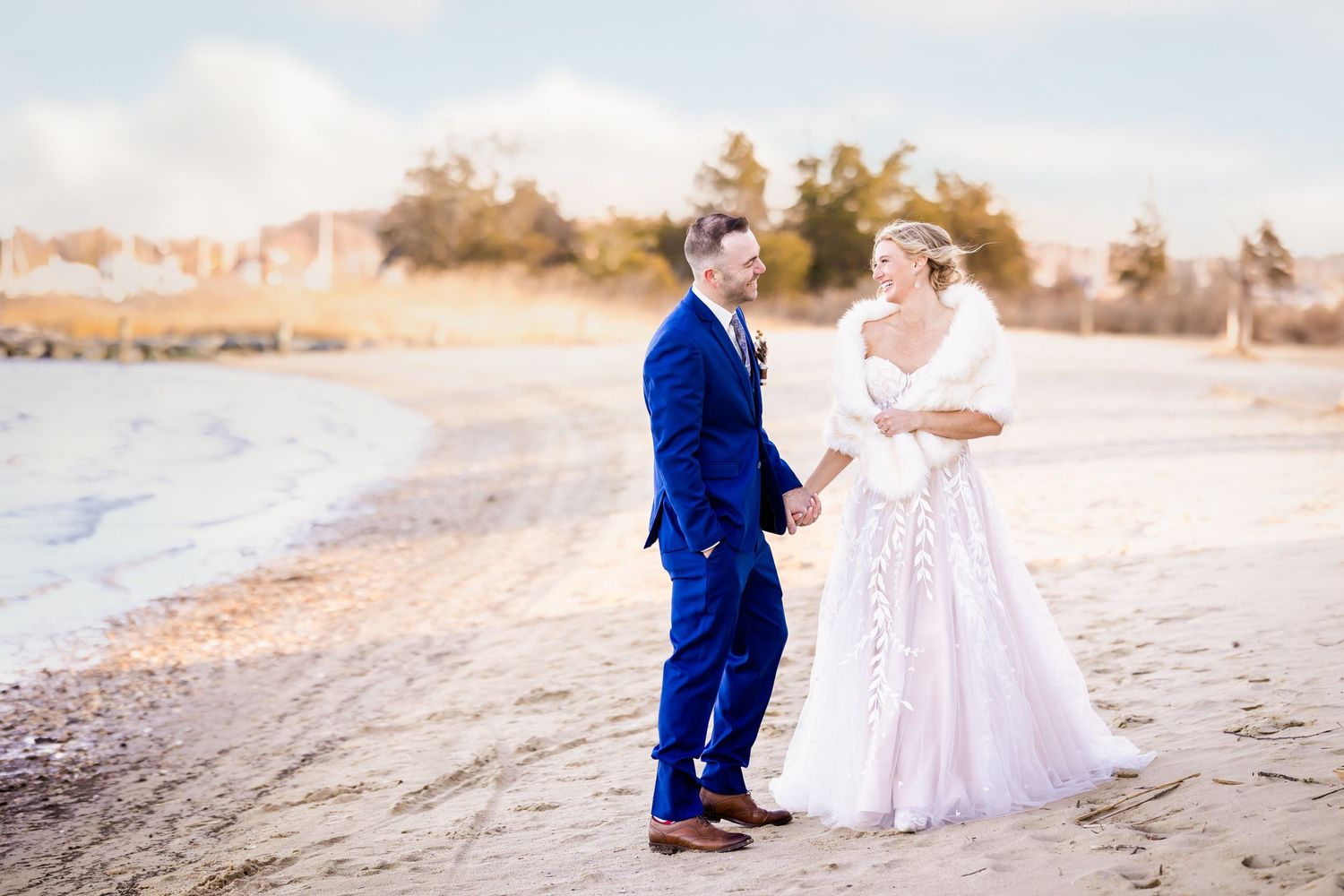 A couple shares an intimate moment on a sandy beach during their wedding.