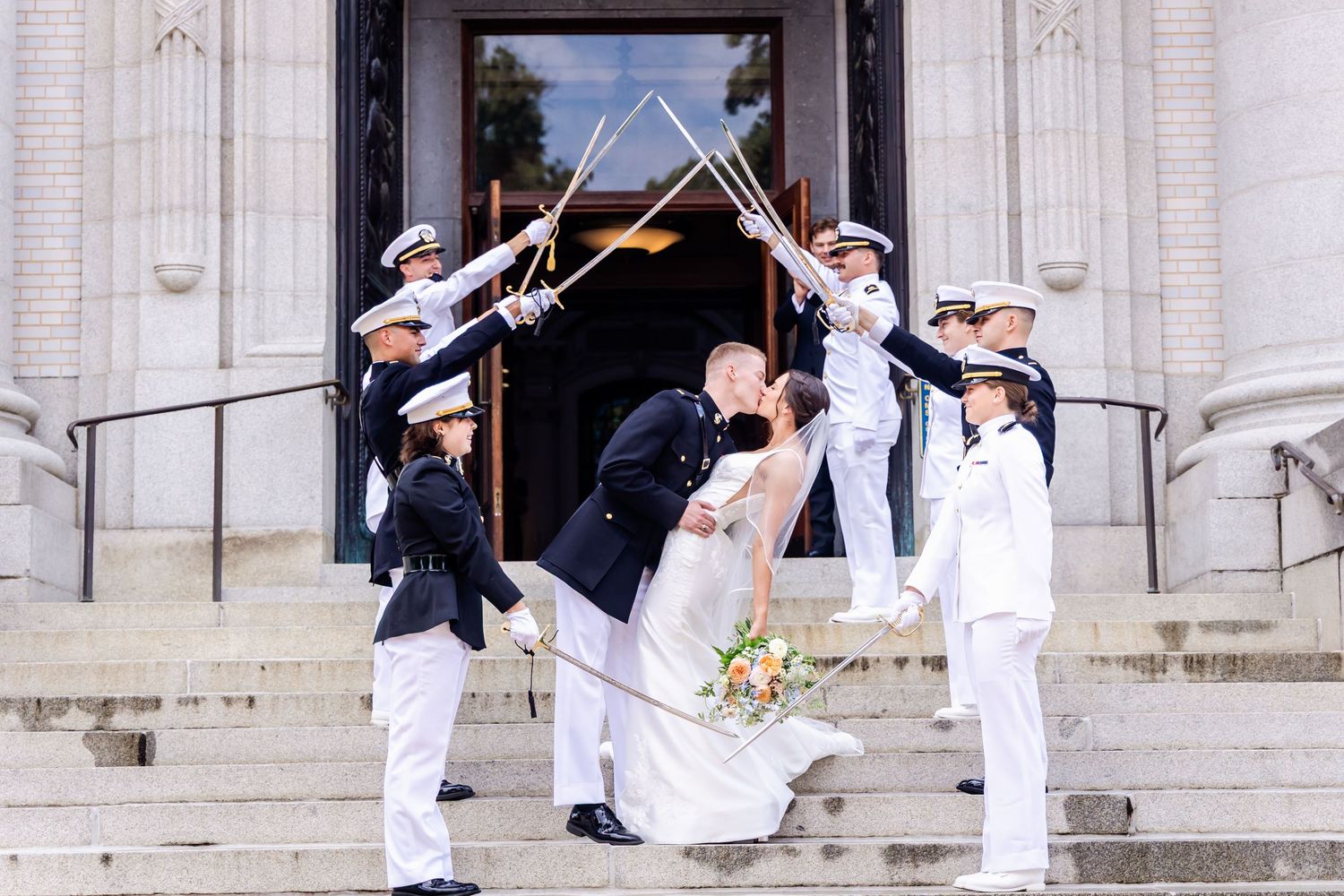 Military wedding ceremony with sword arch salute on stone steps.