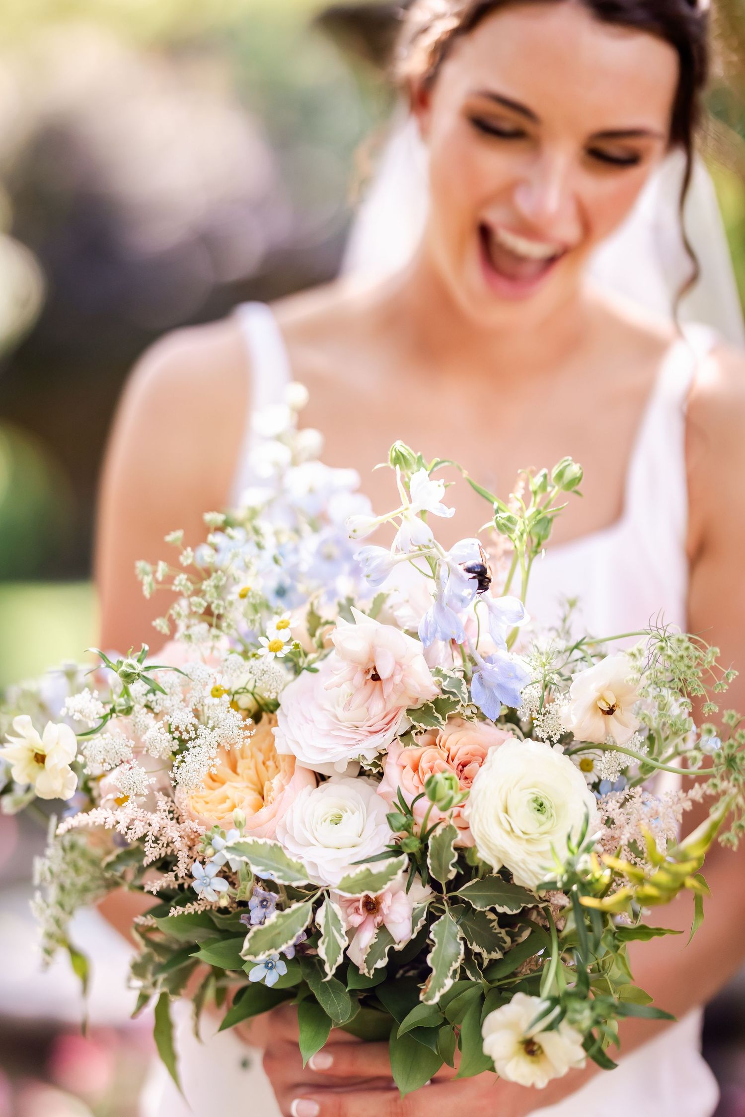 Romantic spring wedding bouquet with soft pink roses, white flowers and delicate greenery.