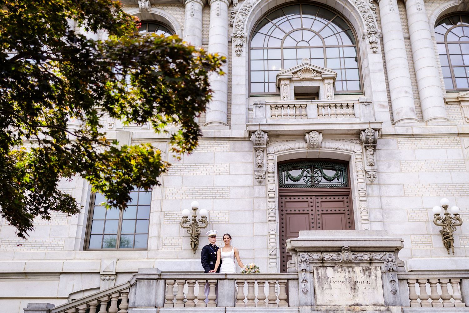 Historic stone building with arched windows serves as elegant wedding venue backdrop.