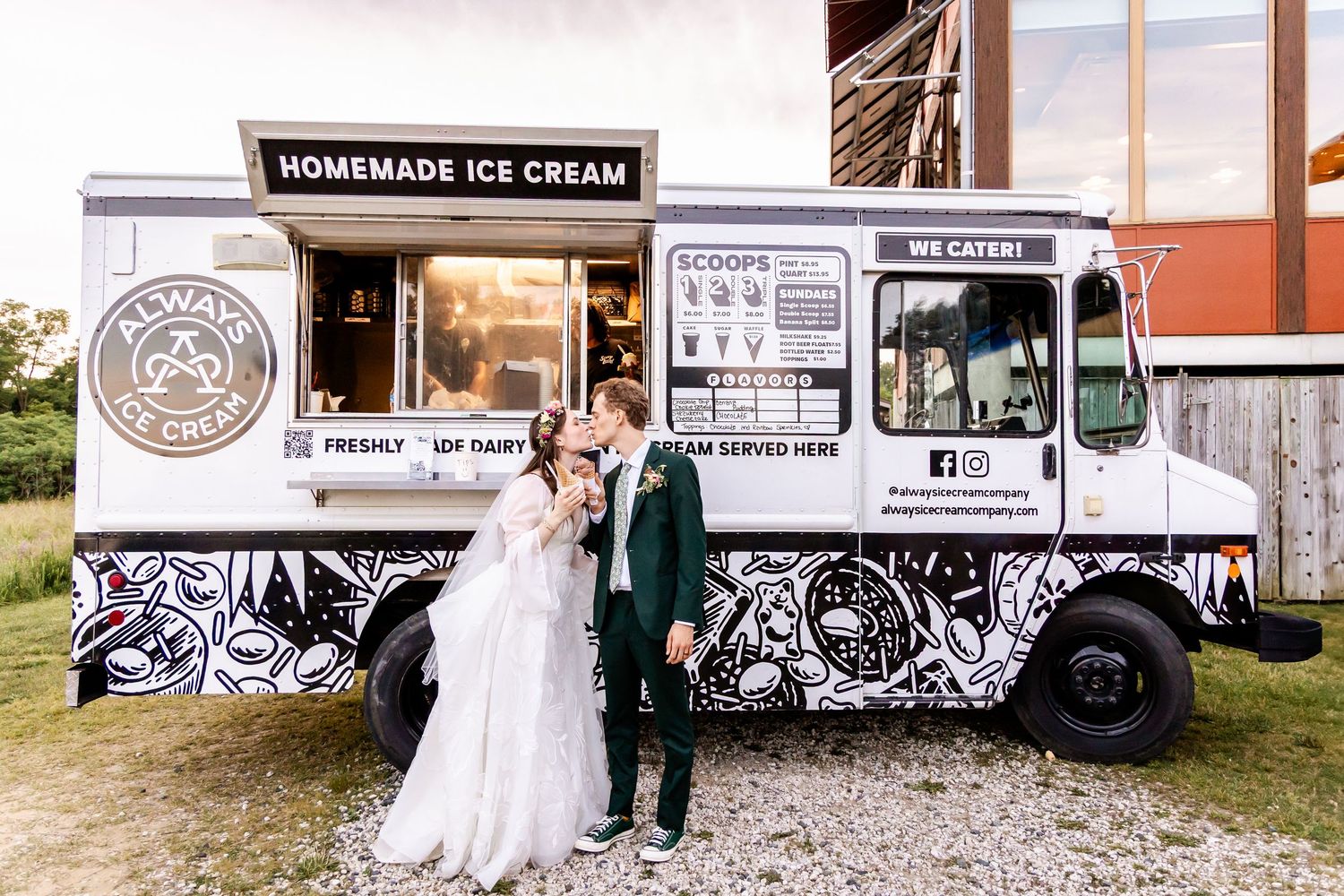 A vintage ice cream truck with black and white designs serves as a charming backdrop for a wedding photo shoot.