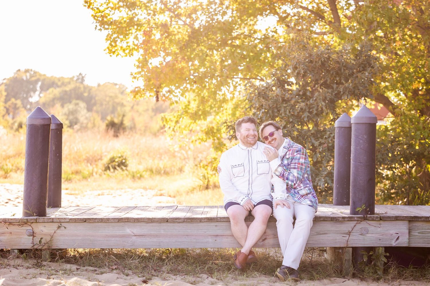 Children sit together on a rustic wooden deck surrounded by autumn trees and golden sunlight.