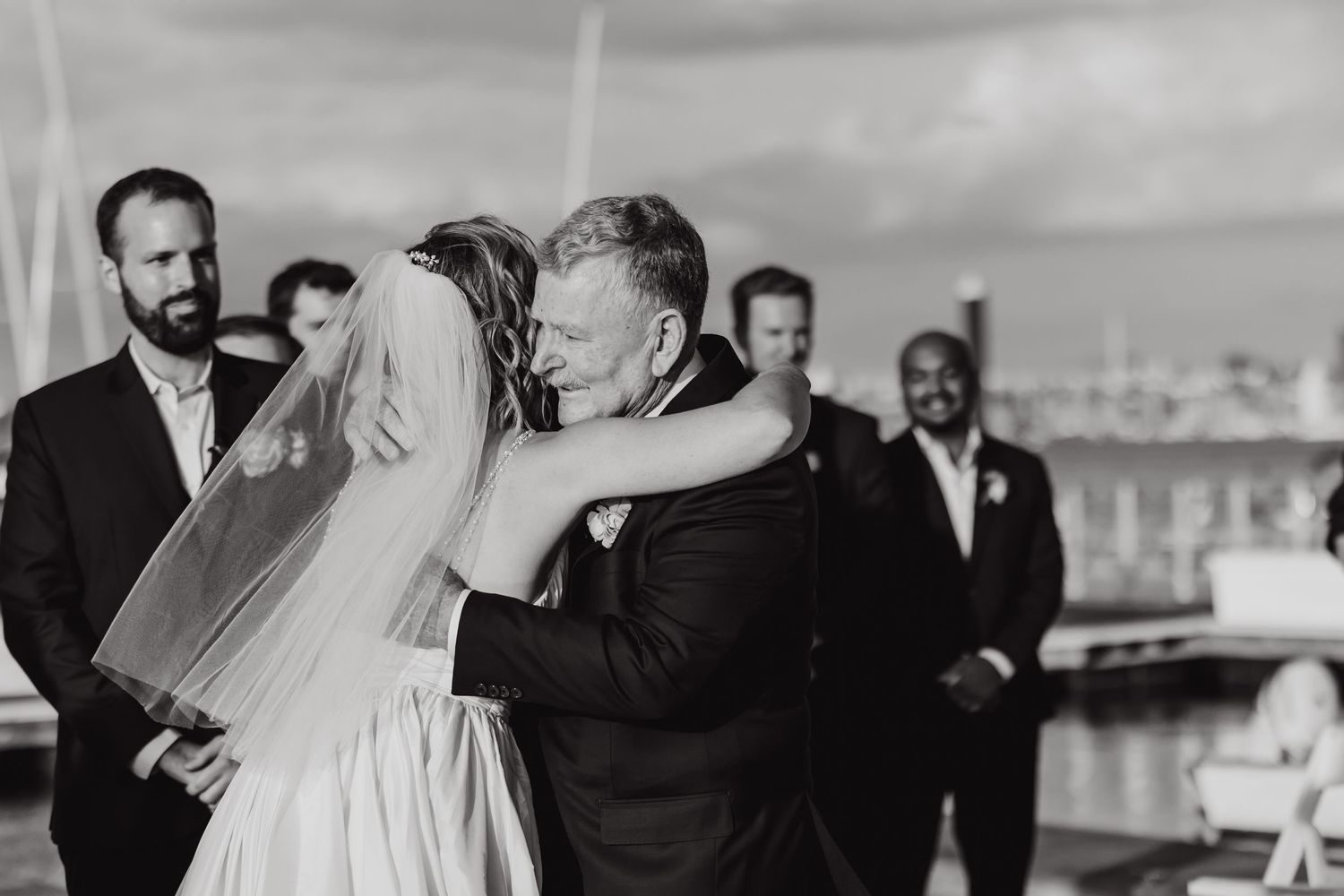 Black and white photo of an emotional moment during a wedding ceremony on a boat.