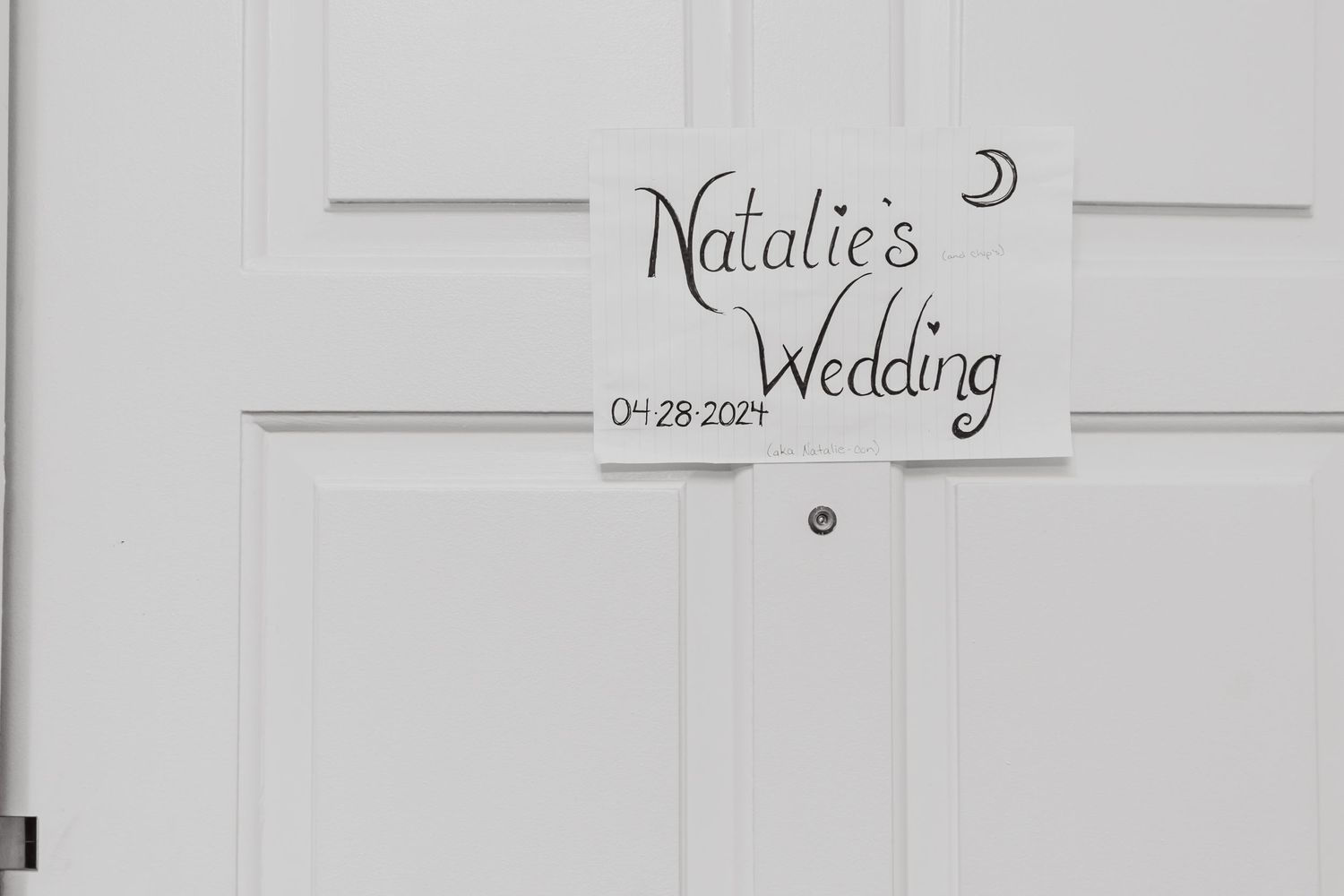 White door with decorative sign reading 'Natalie's Wedding' and date.