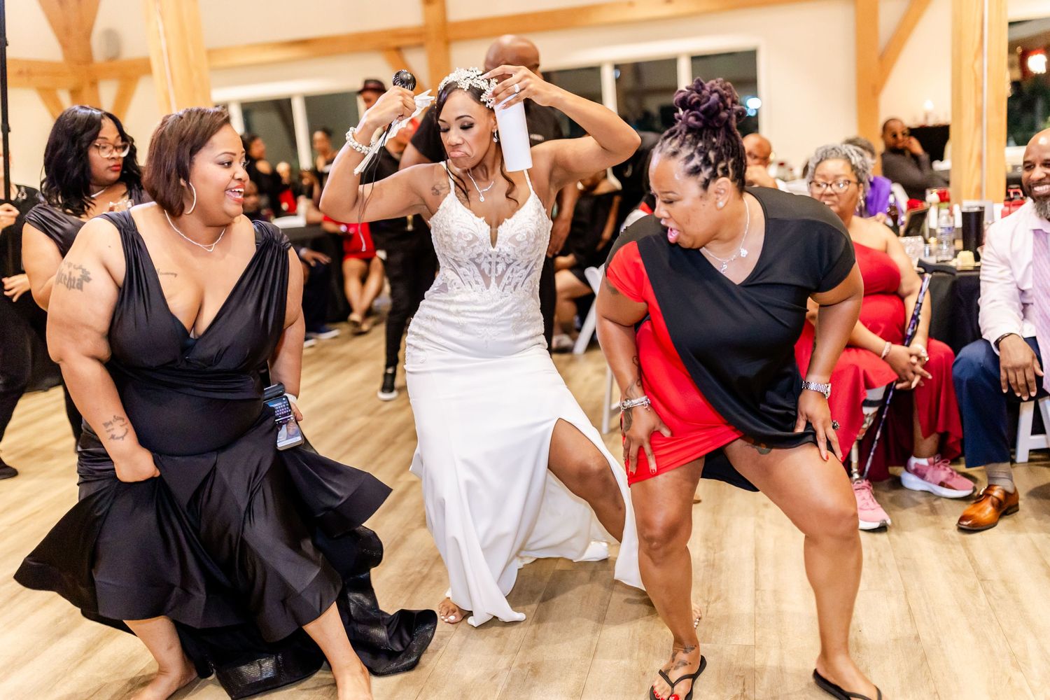 Wedding guests performing synchronized dance moves on a wooden floor during the reception.