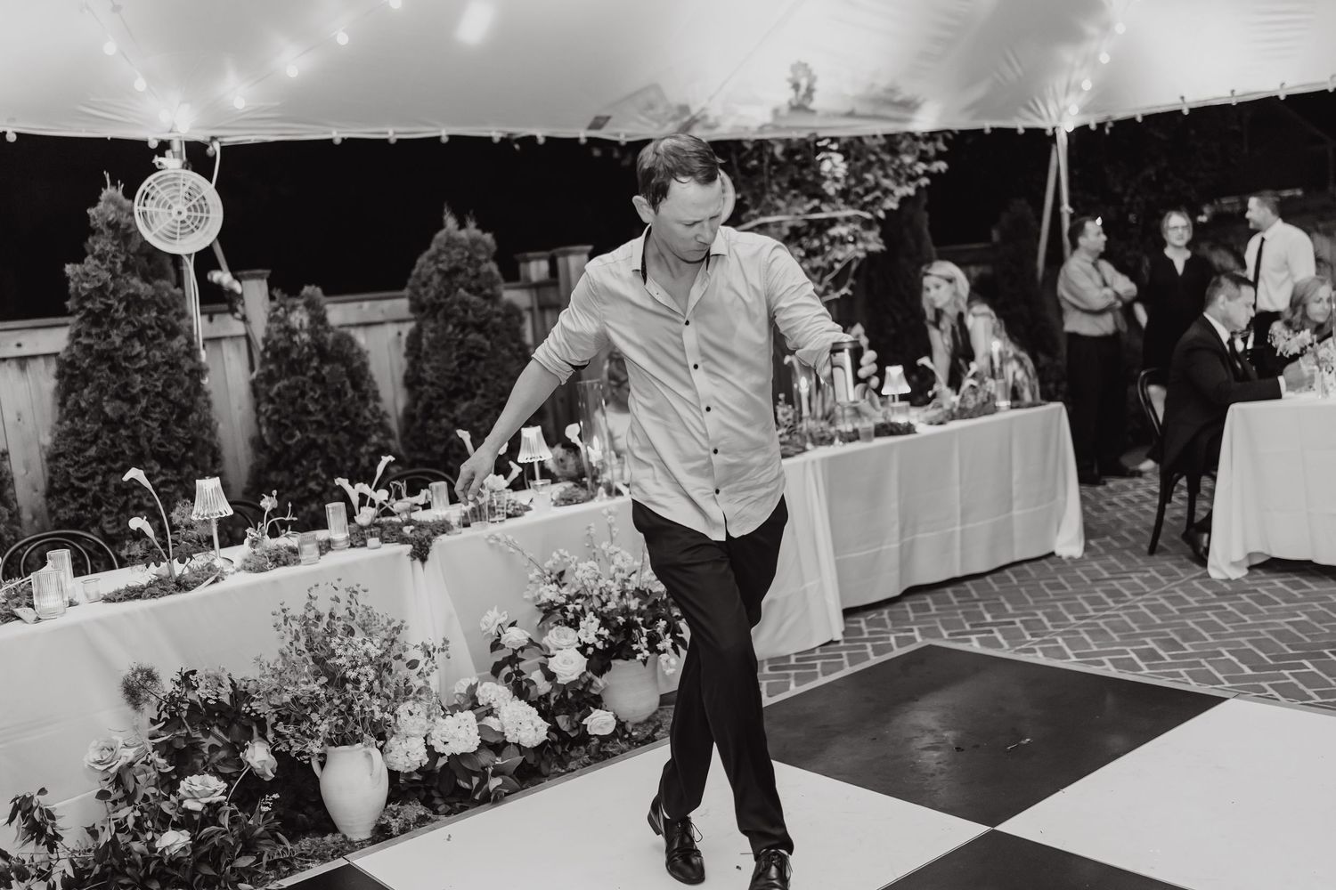 Black and white photo of a dance floor filled with wedding guests celebrating.