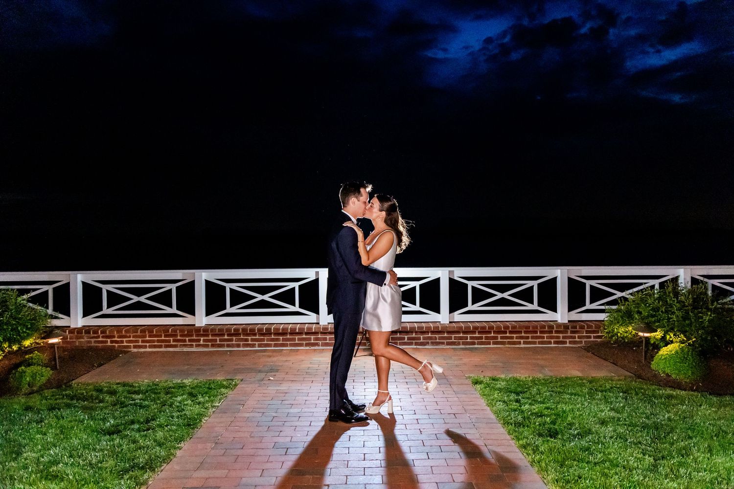 Couple embraces in a romantic nighttime photoshoot with dramatic lighting and smoke effects.