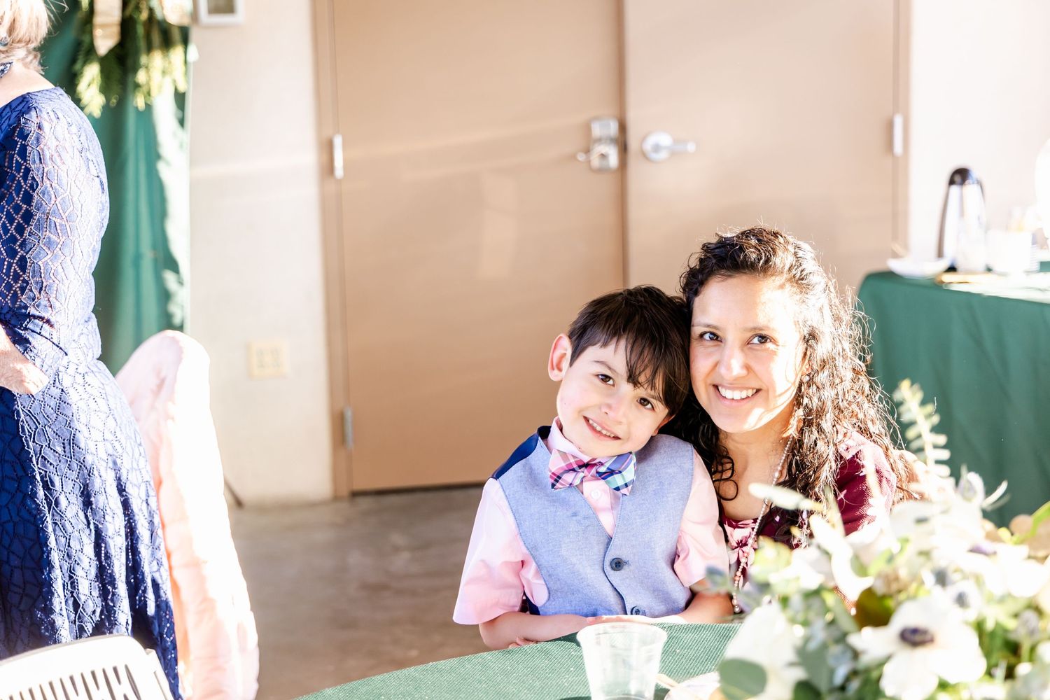 People sitting together at a formal event with table decorations and a mint green tablecloth.