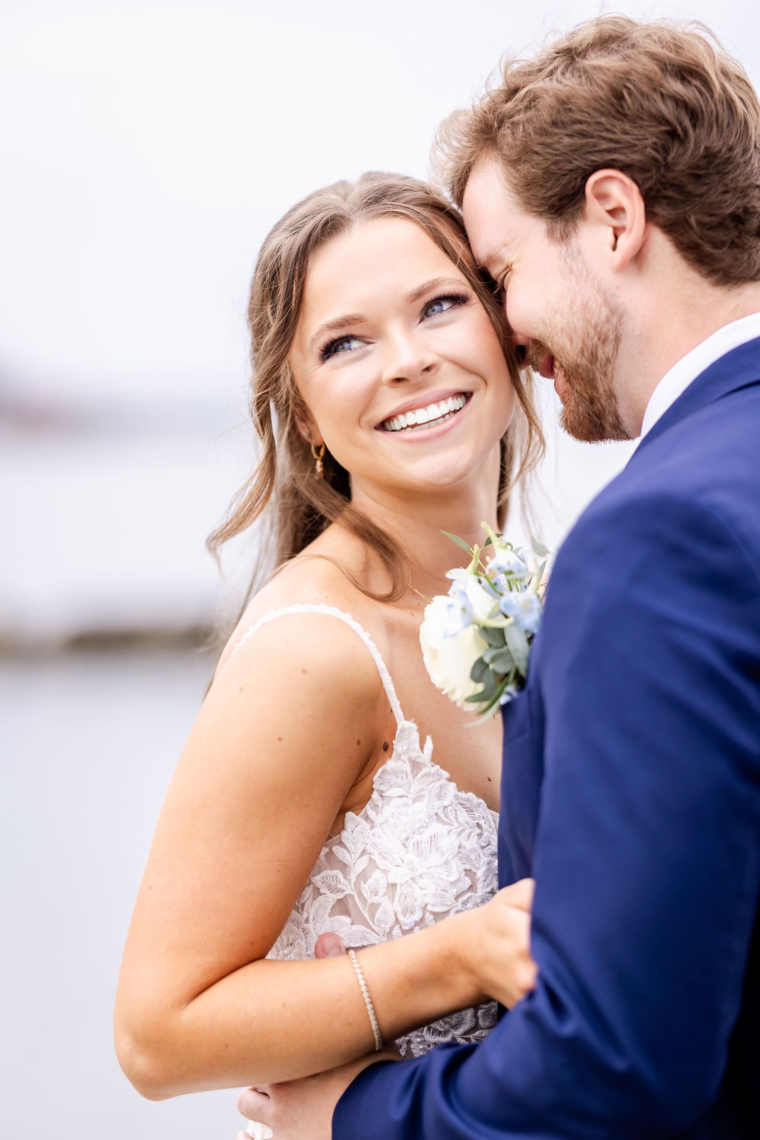 Candid moments of newlyweds laughing and embracing during their waterfront wedding photoshoot.