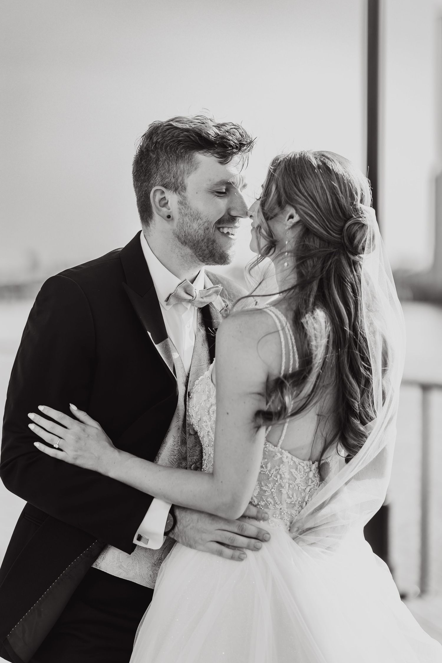 A romantic black and white photo series showing a couple sharing tender kisses on their wedding day.