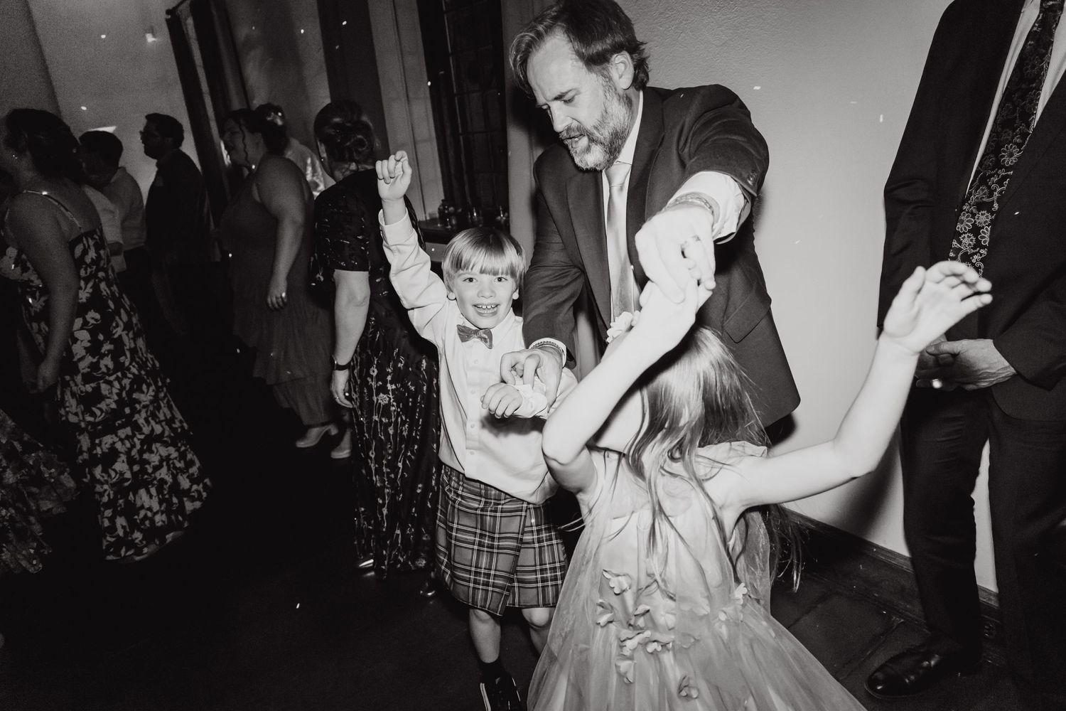 A black and white vintage photo of dancing and celebration at a wedding reception.