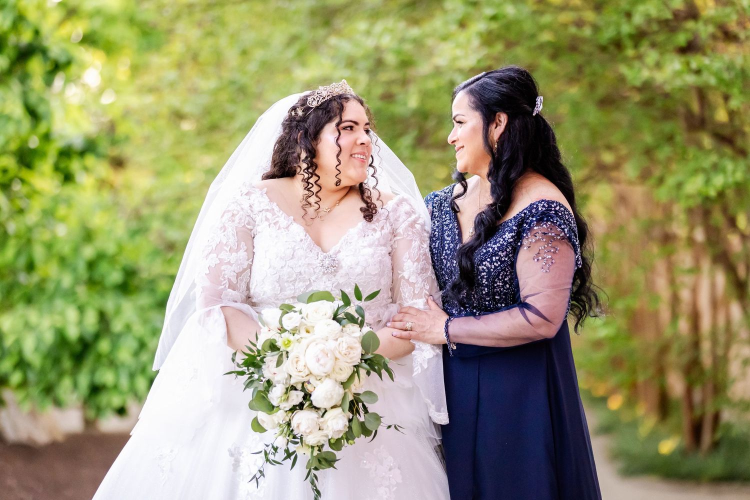 Wedding moment captured in garden setting with white floral bouquet.