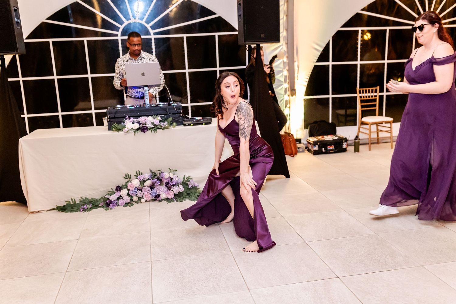 People dancing and celebrating at a wedding reception in an elegant tent venue.