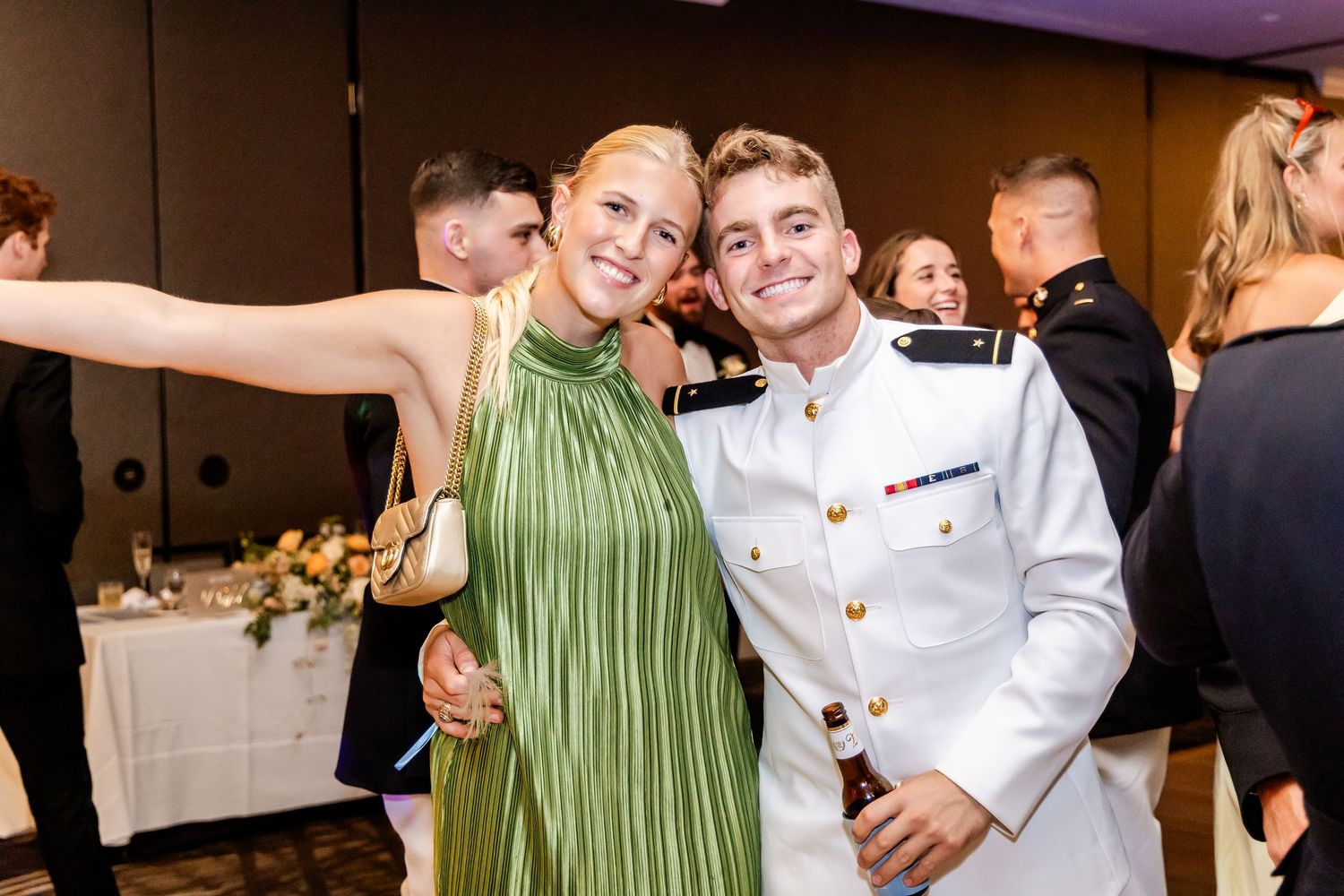Wedding celebration with military service member and guest posing enthusiastically at reception.