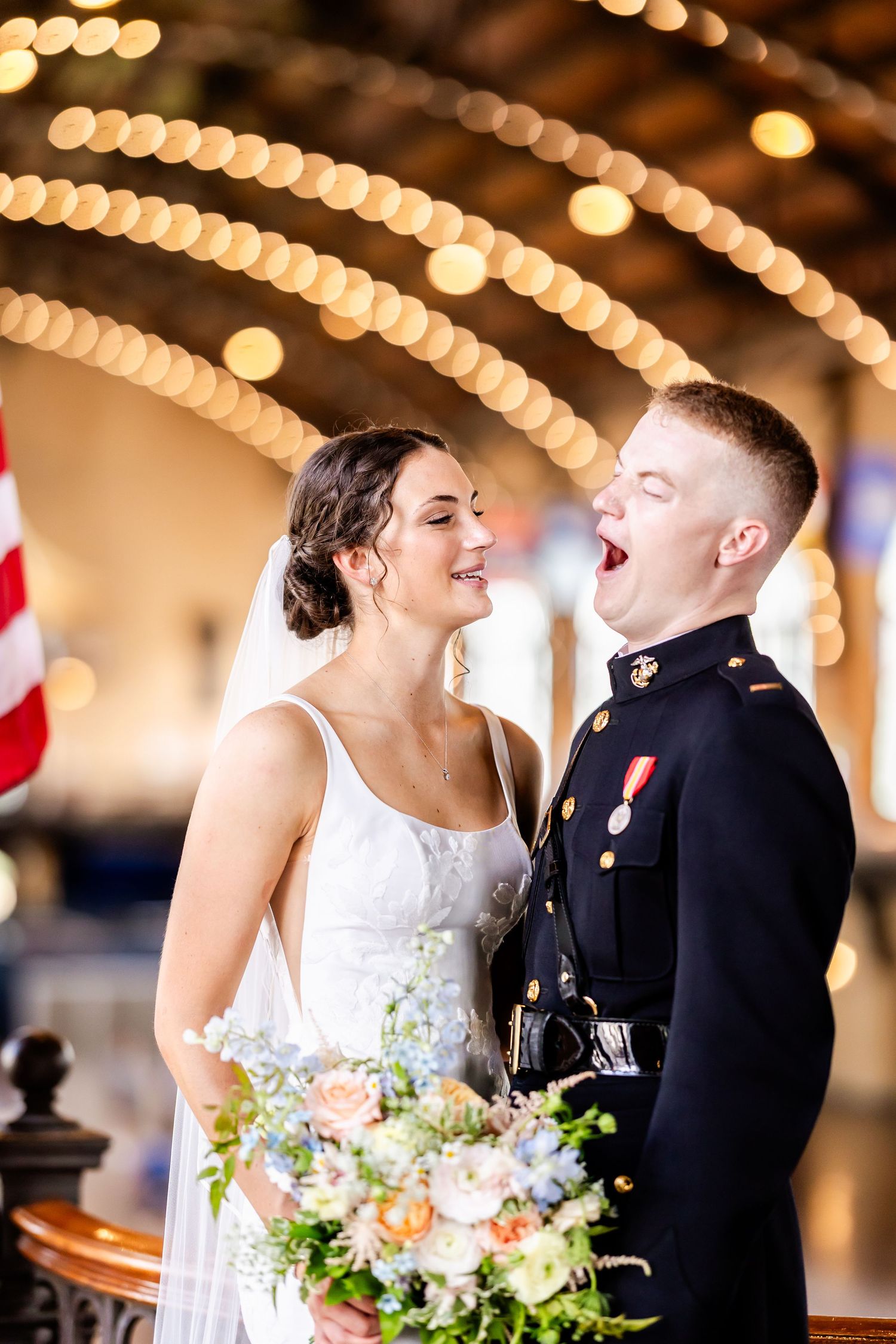 Romantic wedding couple shares intimate moment under twinkling lights at their reception.