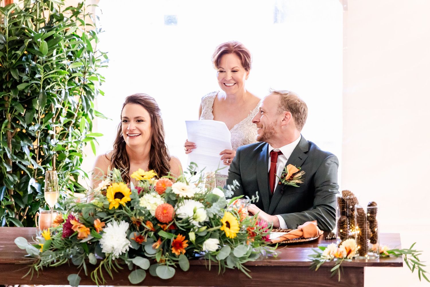 Wedding reception table decorated with colorful floral arrangements and rustic decor at an outdoor venue.