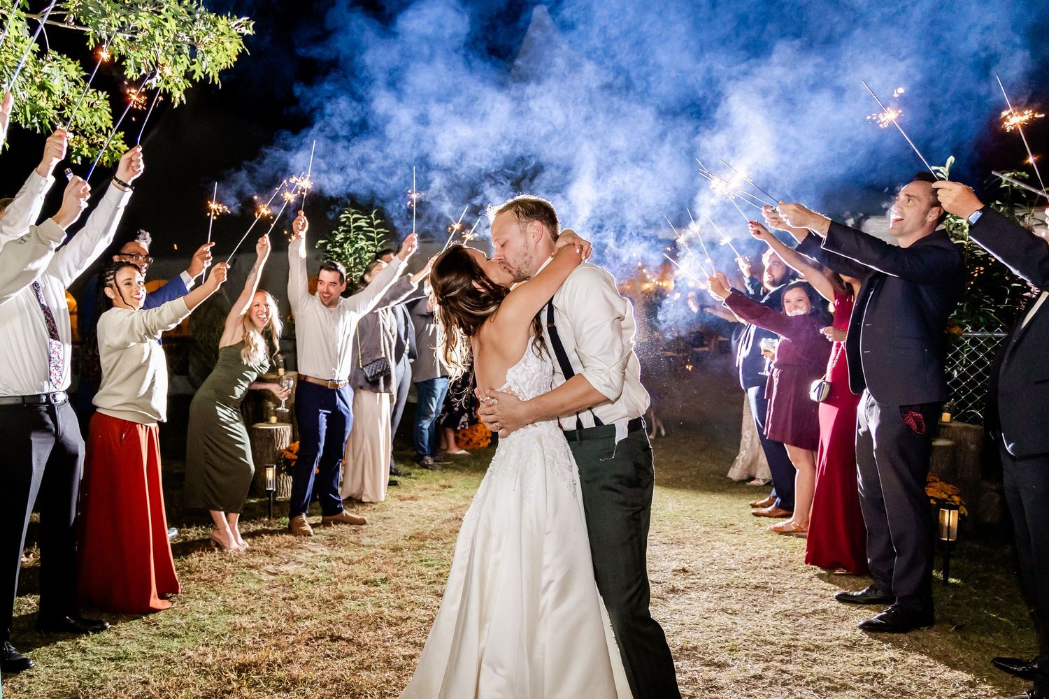 Romantic nighttime wedding exit with sparklers creating a magical atmosphere.