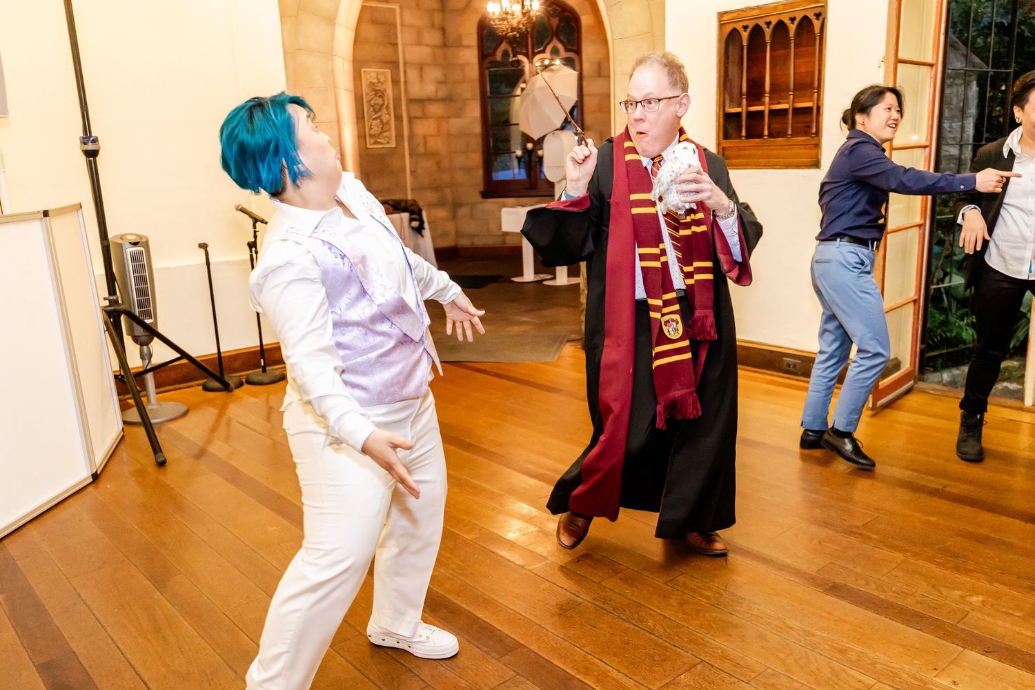 Costumed performers dance and interact during celebratory event in ornate indoor venue.