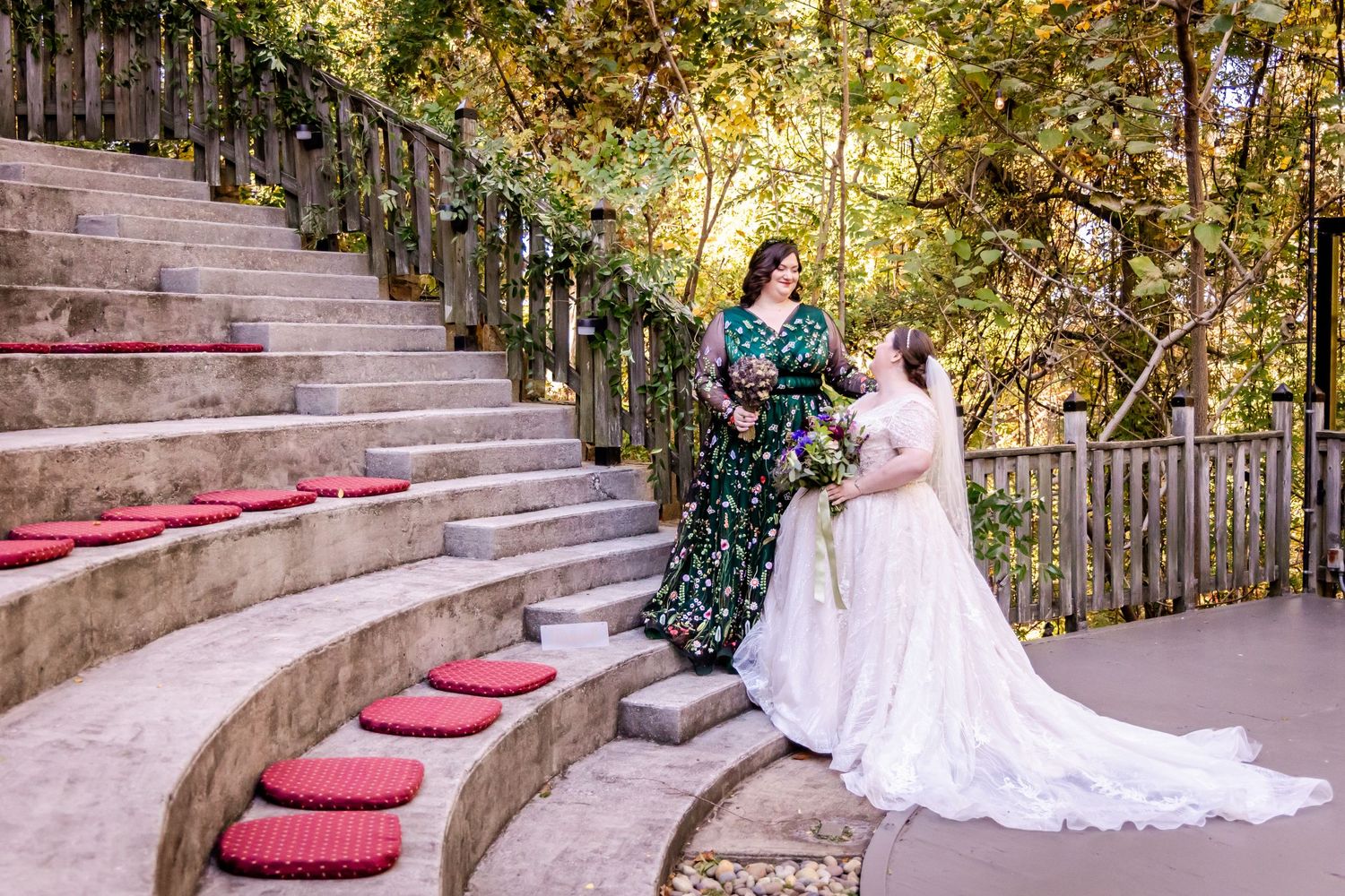 Beautiful autumn wedding scene on stone steps decorated with red cushions and natural foliage.