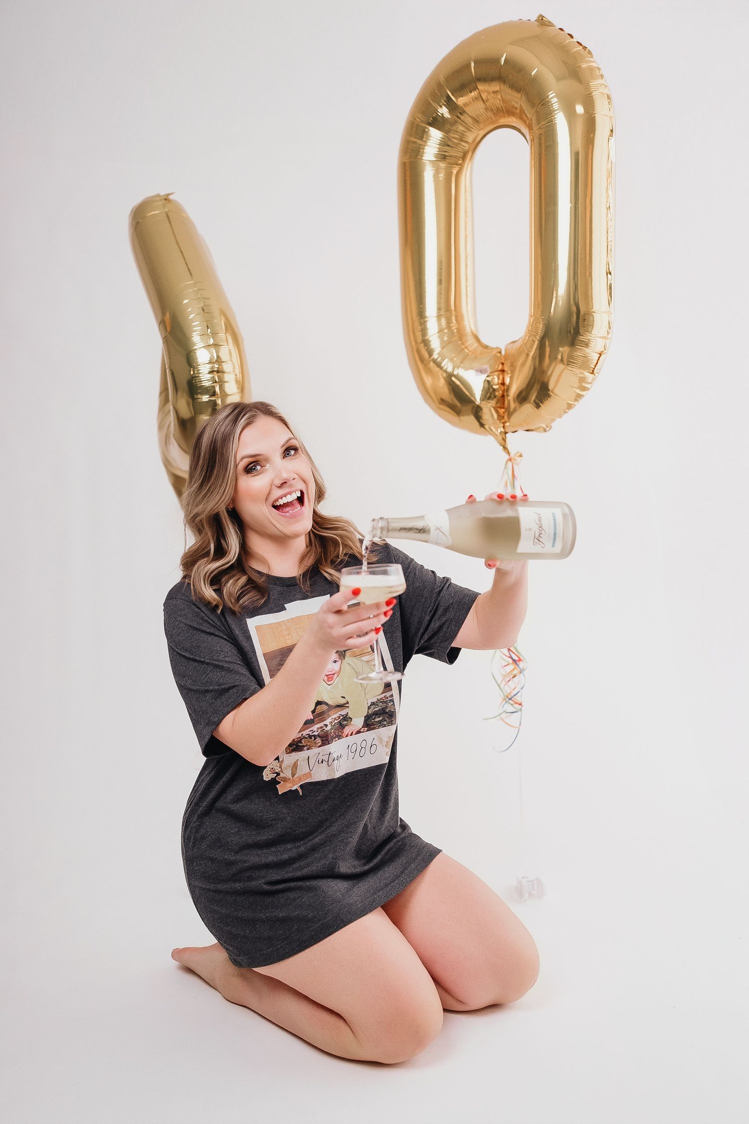 Celebratory photos with gold number balloons and champagne glass on white background.