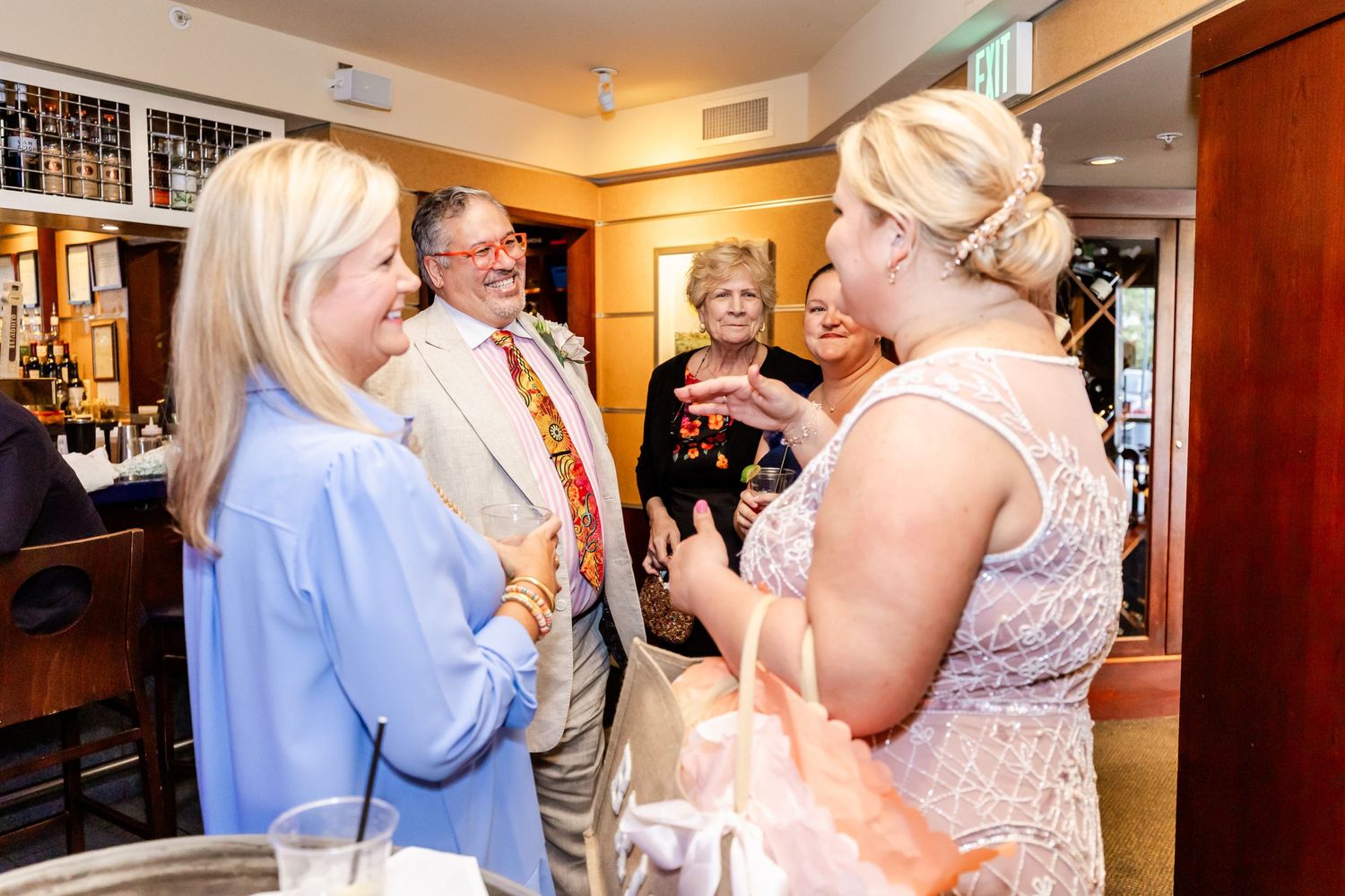 Small group engaged in animated conversation during an indoor social gathering.