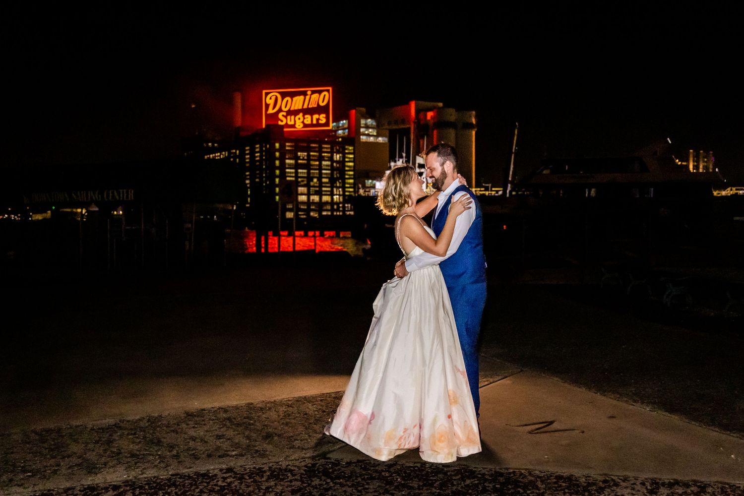 Romantic nighttime dance with illuminated Hampton Inn sign glowing in the background.