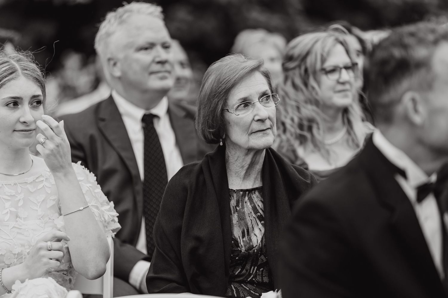 Wedding guests enjoying a celebratory moment in black and white photography.
