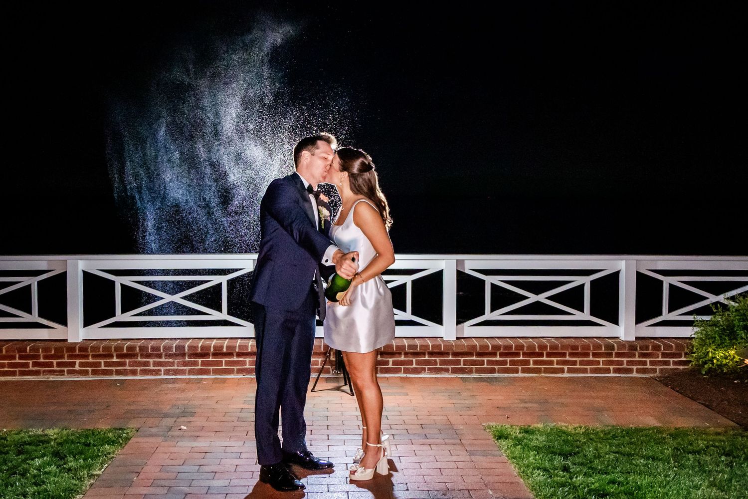 Romantic wedding couple poses with dramatic smoke effects at night.