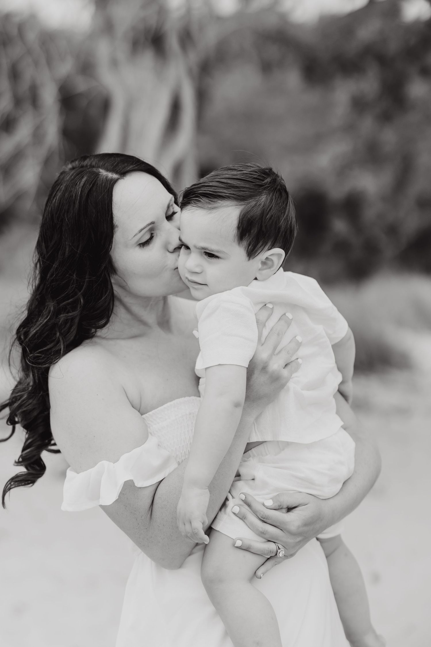 A black and white portrait showing an intimate moment between parent and child.