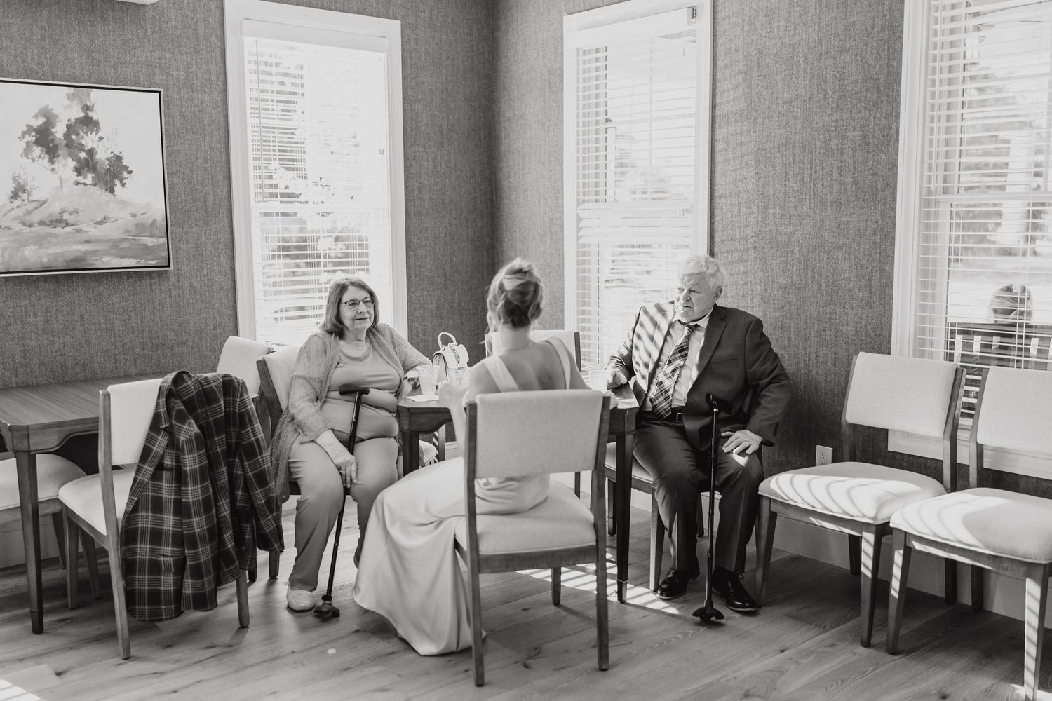 Black and white photo of a minimalist interior room with framed artwork and chairs.