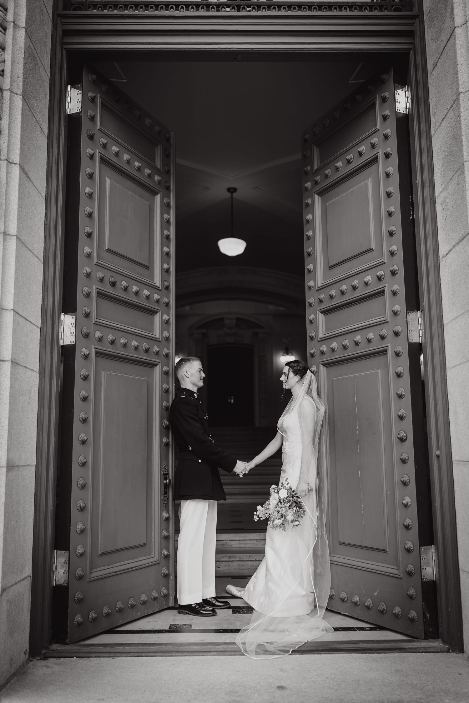An elegant black and white photo showing ornate architectural details of a grand doorway entrance.