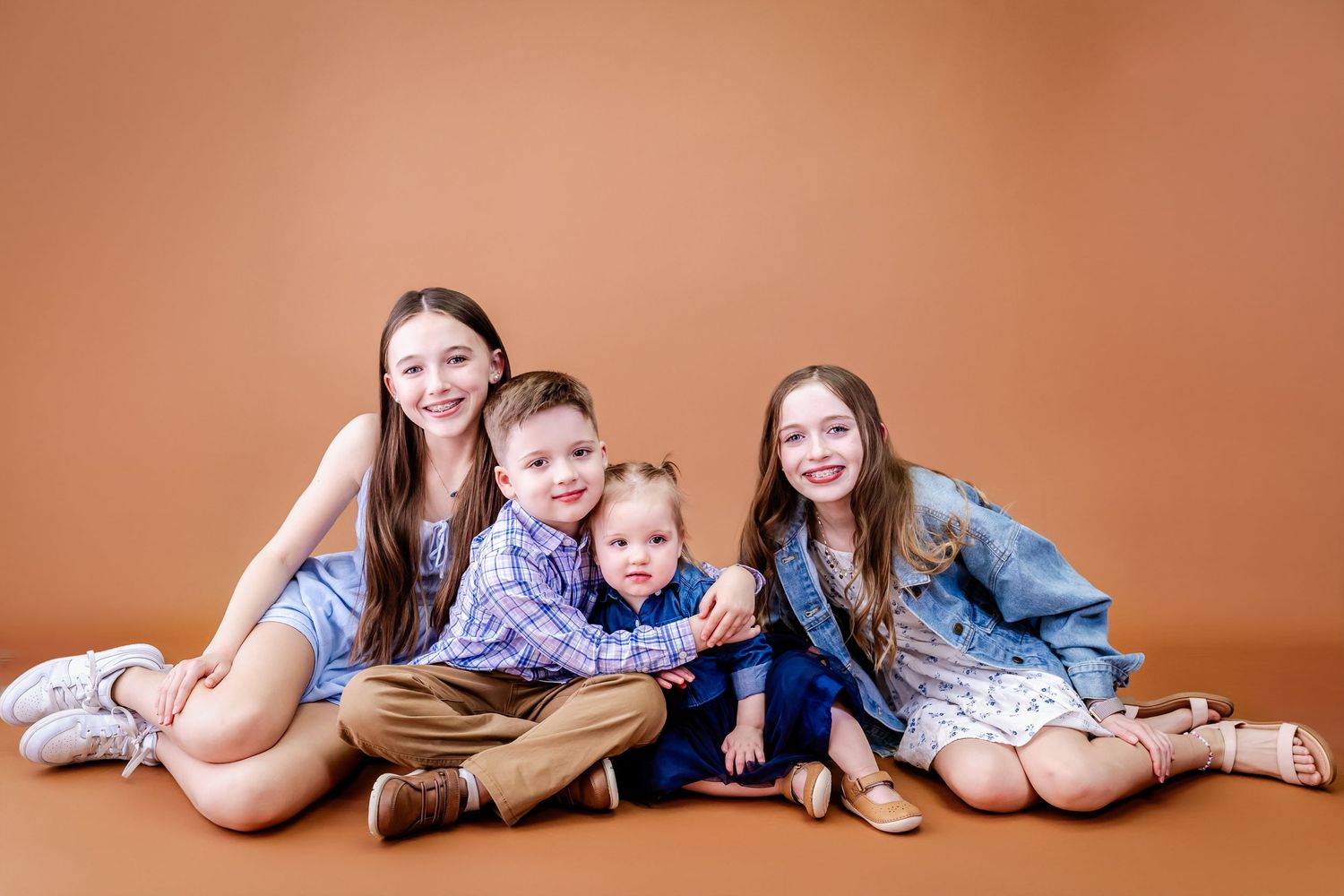 Candid family photos on an orange backdrop showing playful poses and interactions.