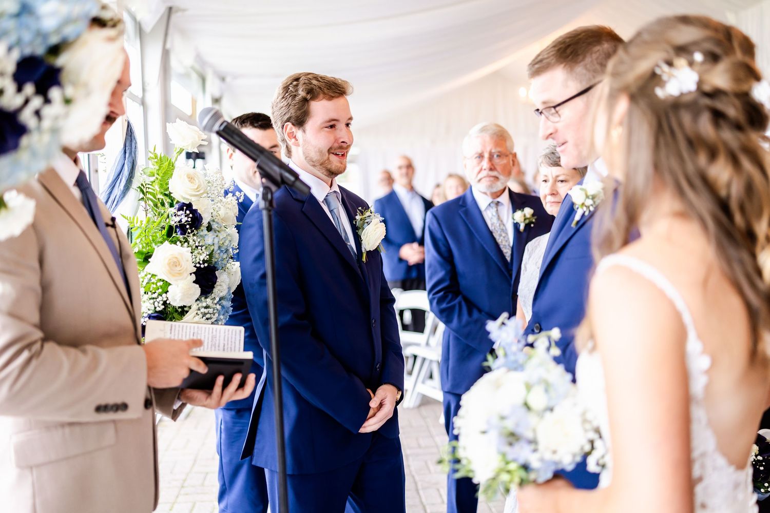 Wedding ceremony moments captured in a bright indoor venue with blue accents.