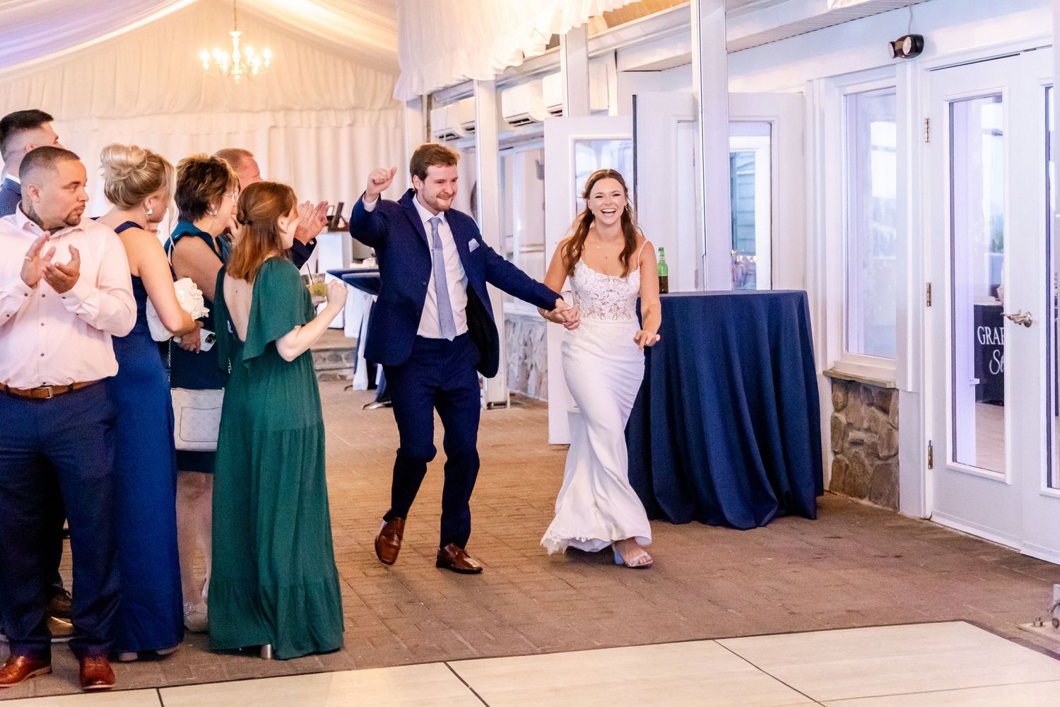 Wedding reception dance floor with guests dancing in formal attire and emerald green dresses.