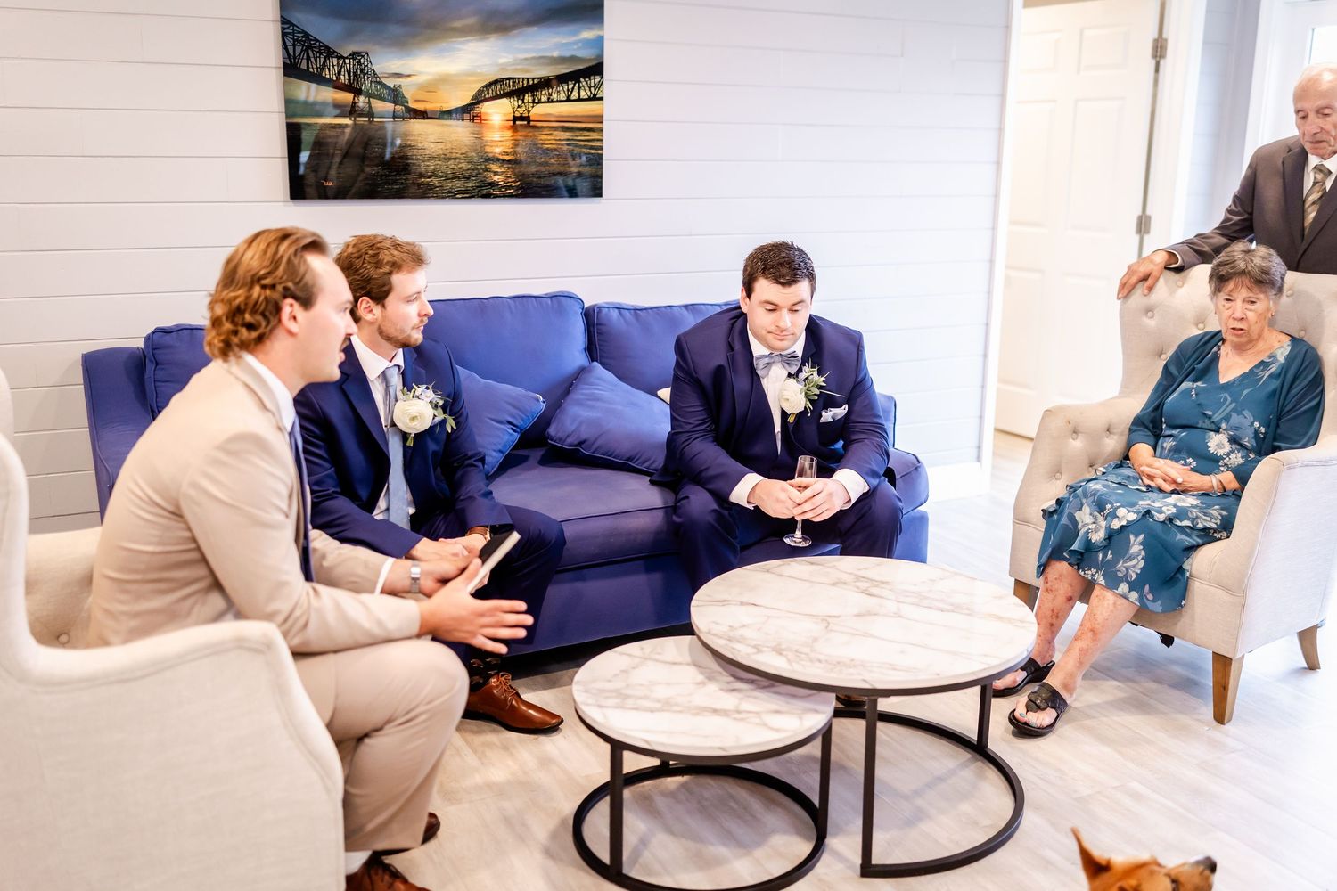 Wedding guests relaxing in a modern lounge area with blue furniture.
