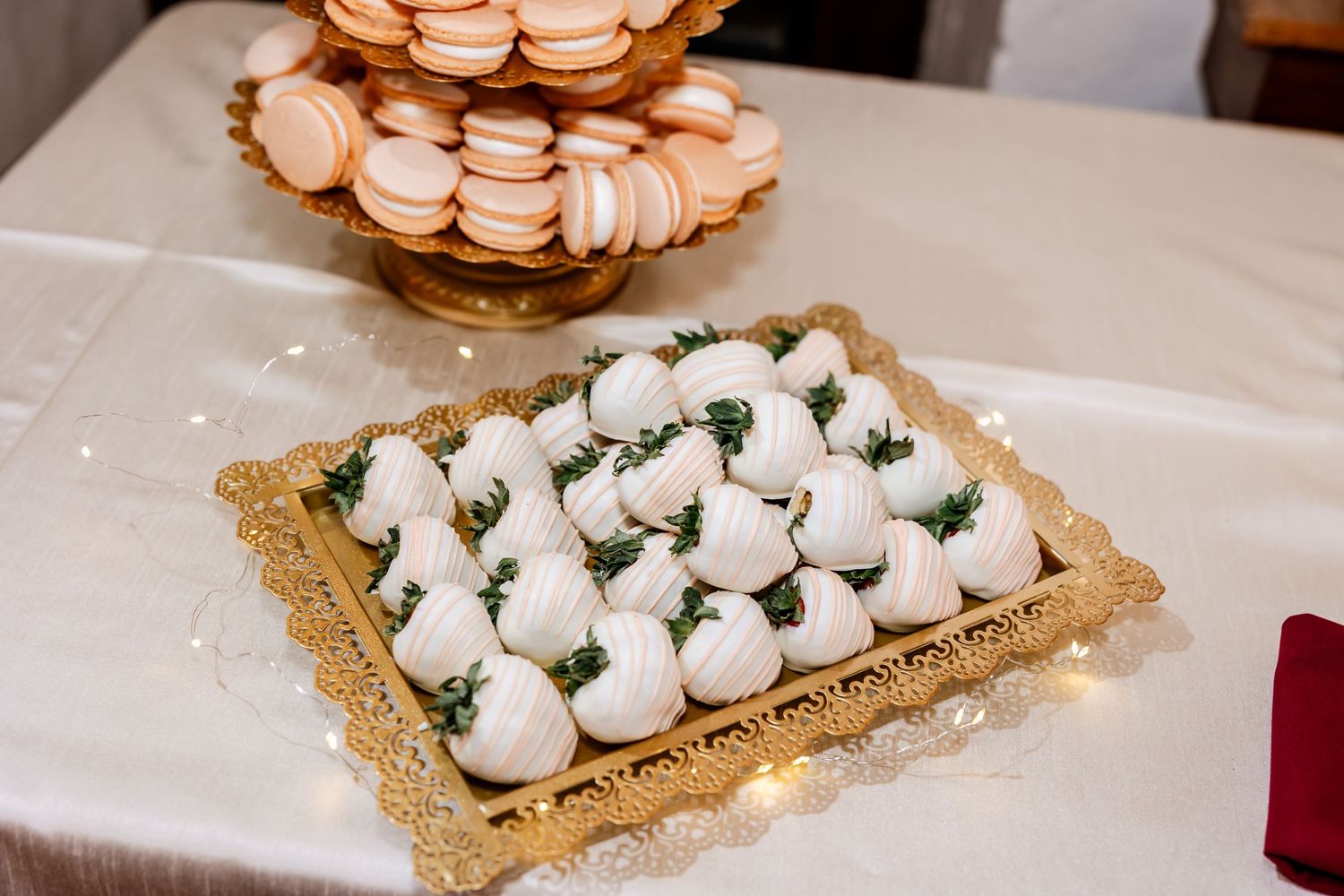 Elegant dessert display featuring rows of delicate macarons on white serving plates.