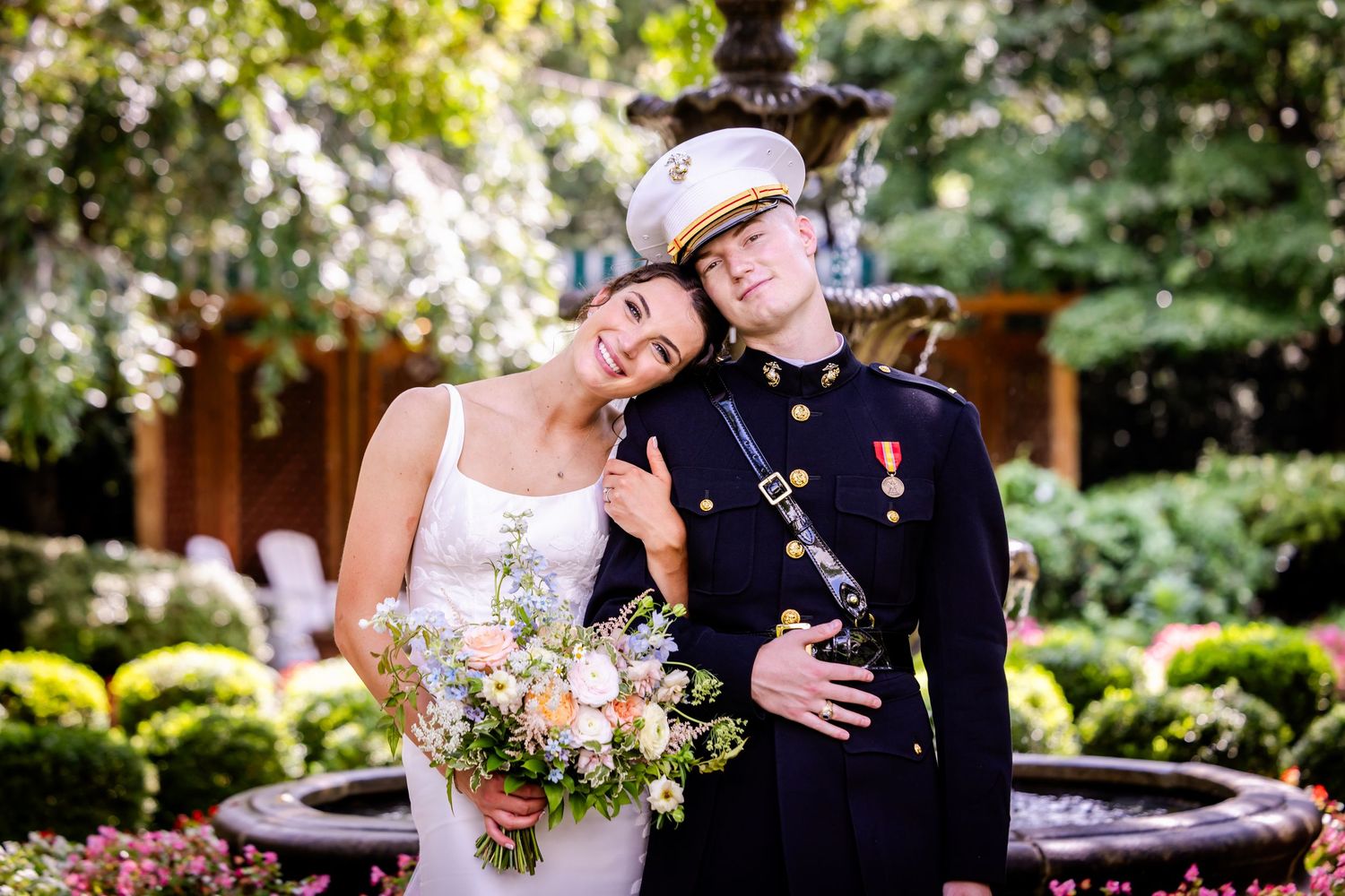 Romantic wedding portrait in a garden setting with elegant bouquet and formal attire.