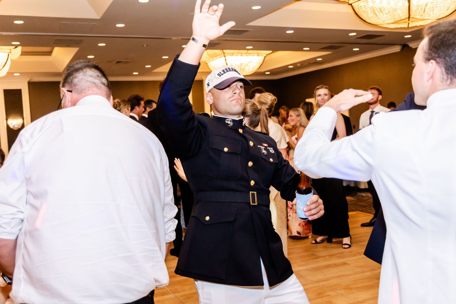 Wedding reception celebration with guests cheering in hotel ballroom.
