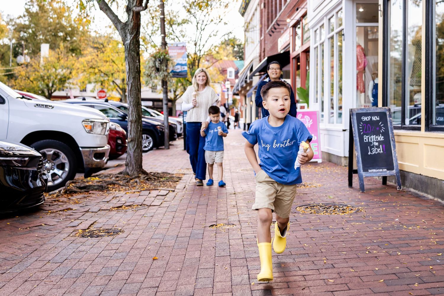 Children playing and running on a brick sidewalk in a historic downtown area.