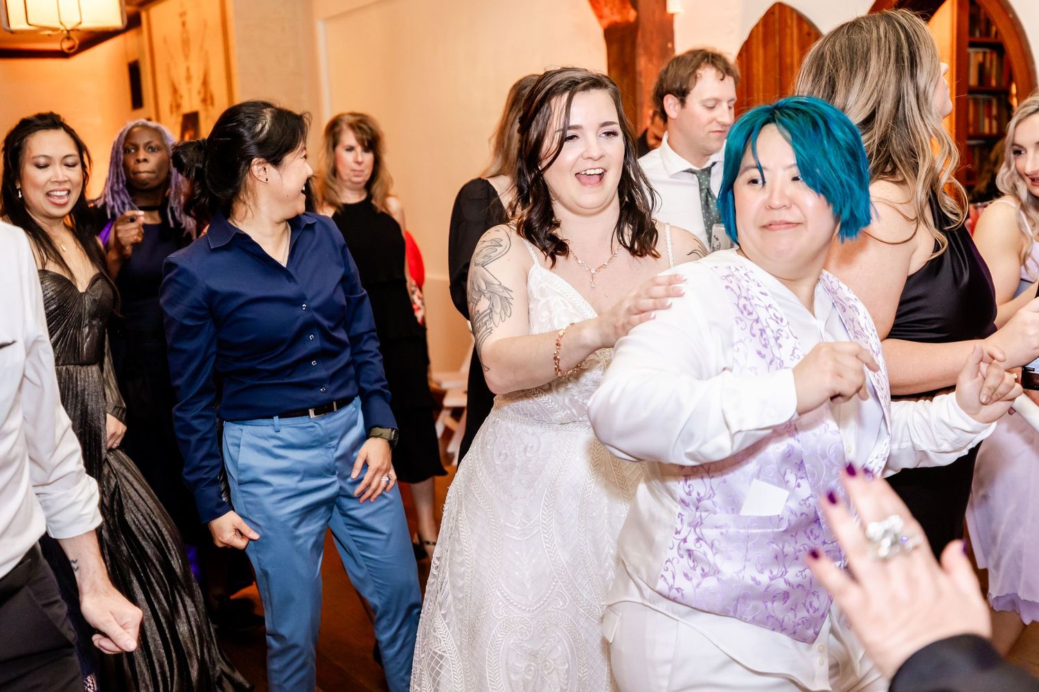 Party guests dancing and having fun together in a venue with arched doorways.