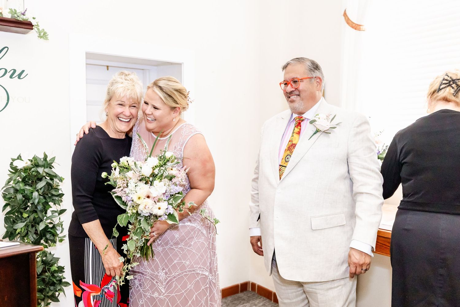 A celebration in a white chapel with floral decorations and elegant attire.