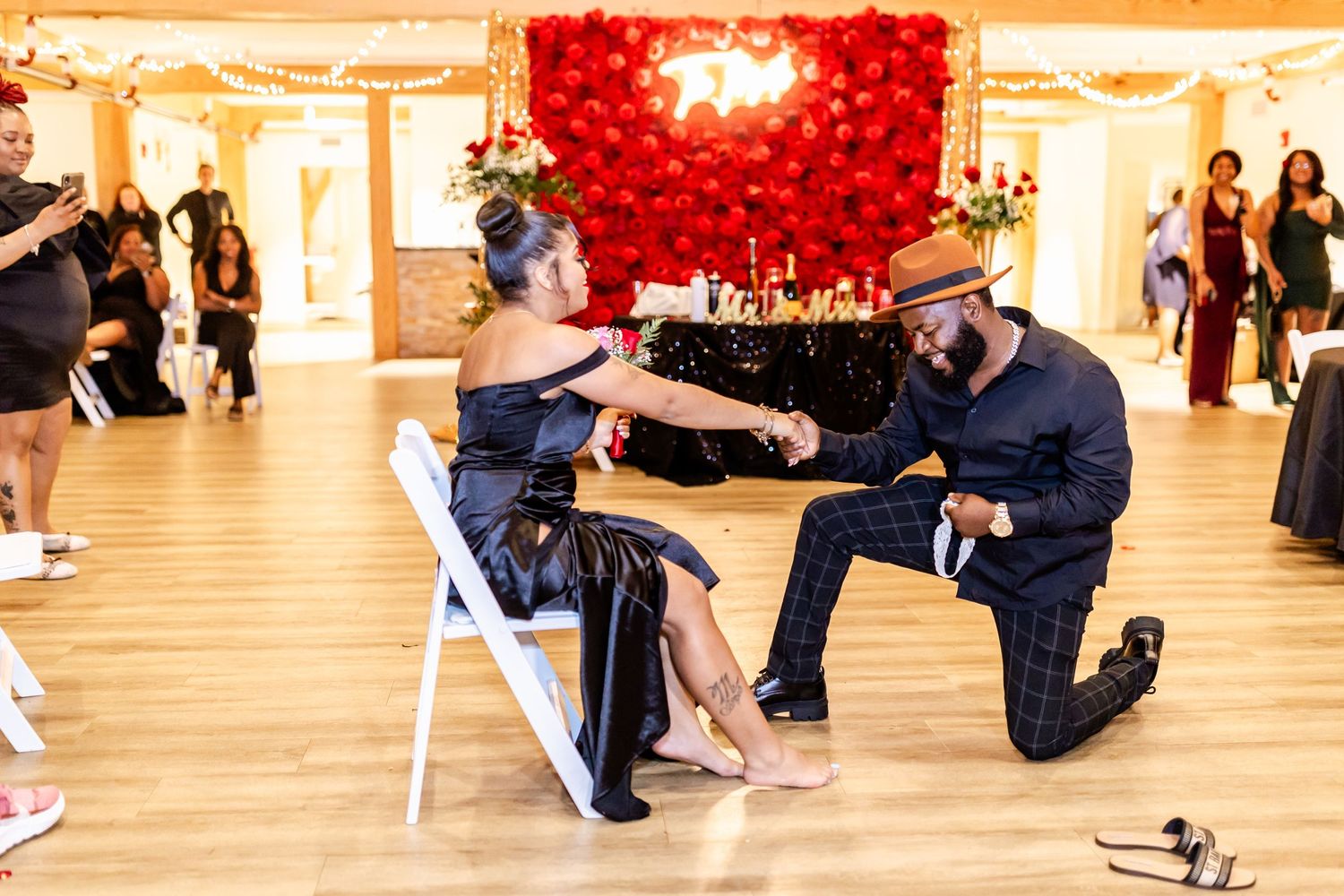 Wedding reception moment with dramatic red balloon wall backdrop and dance floor interaction.